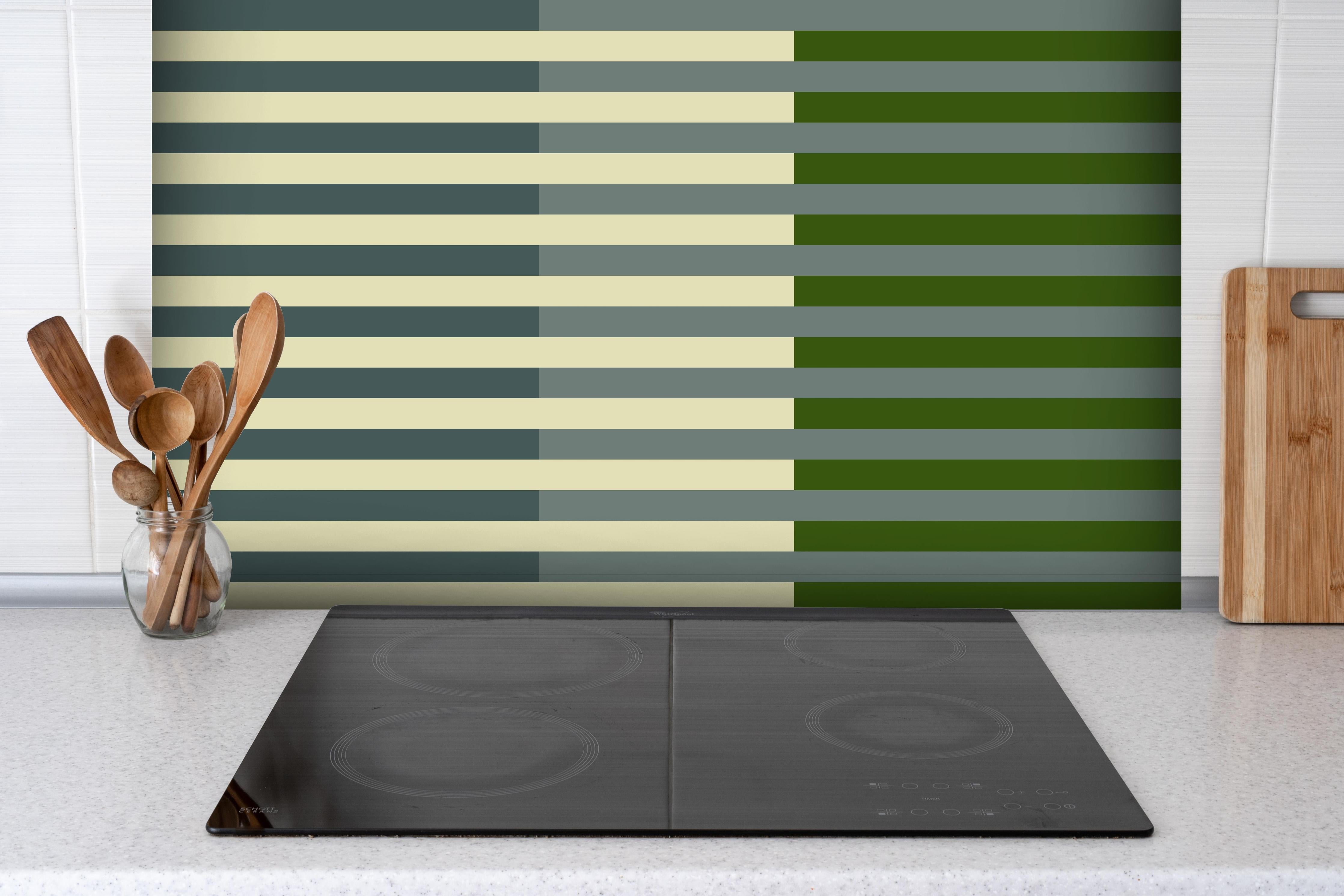 Spritzschutz - The Greens - Multy Stripes - Avocado hinter einem Cerankochfeld zwischen Holz-Kochutensilien