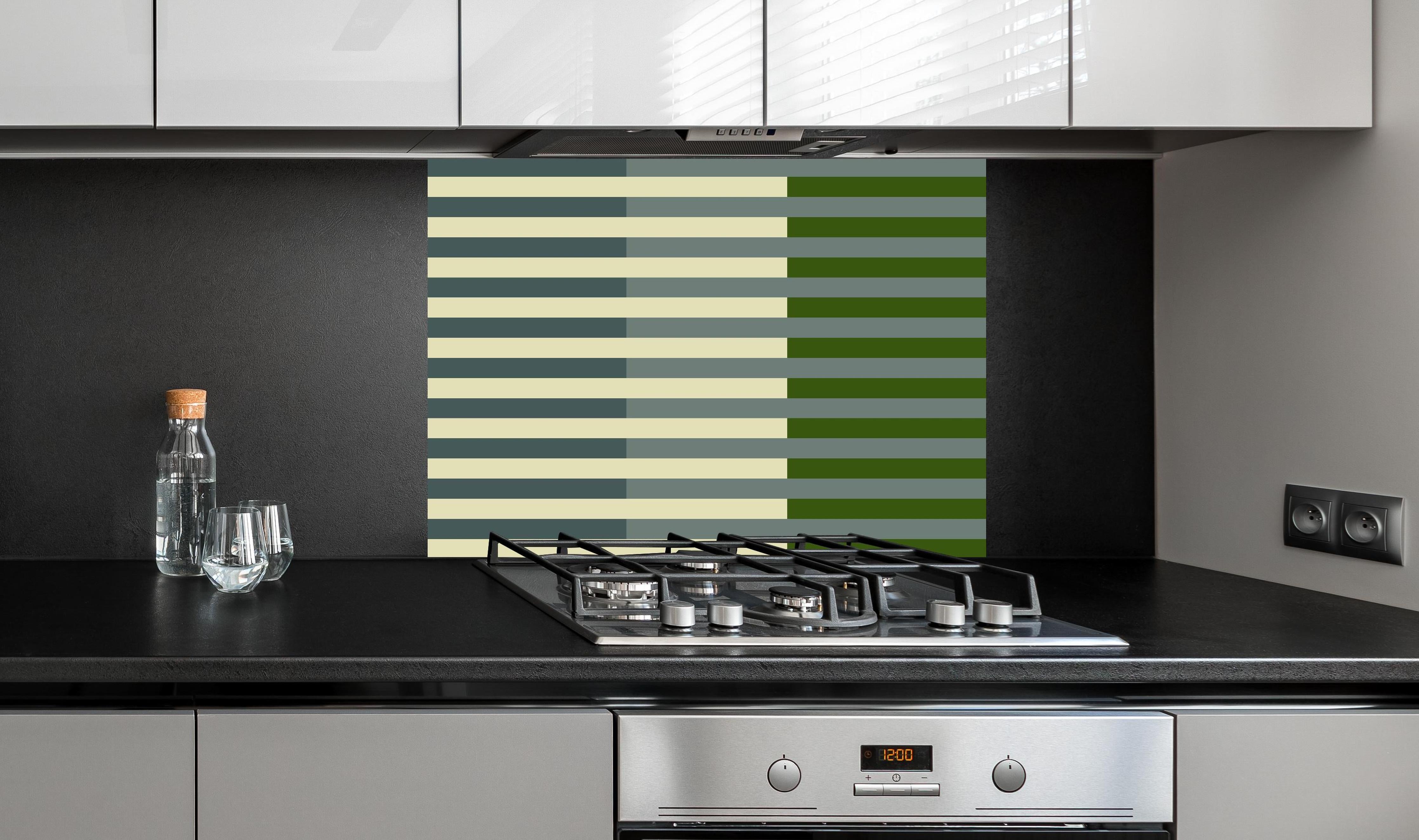 Spritzschutz - The Greens - Multy Stripes - Avocado hinter einem Cerankochfeld zwischen Holz-Kochutensilien