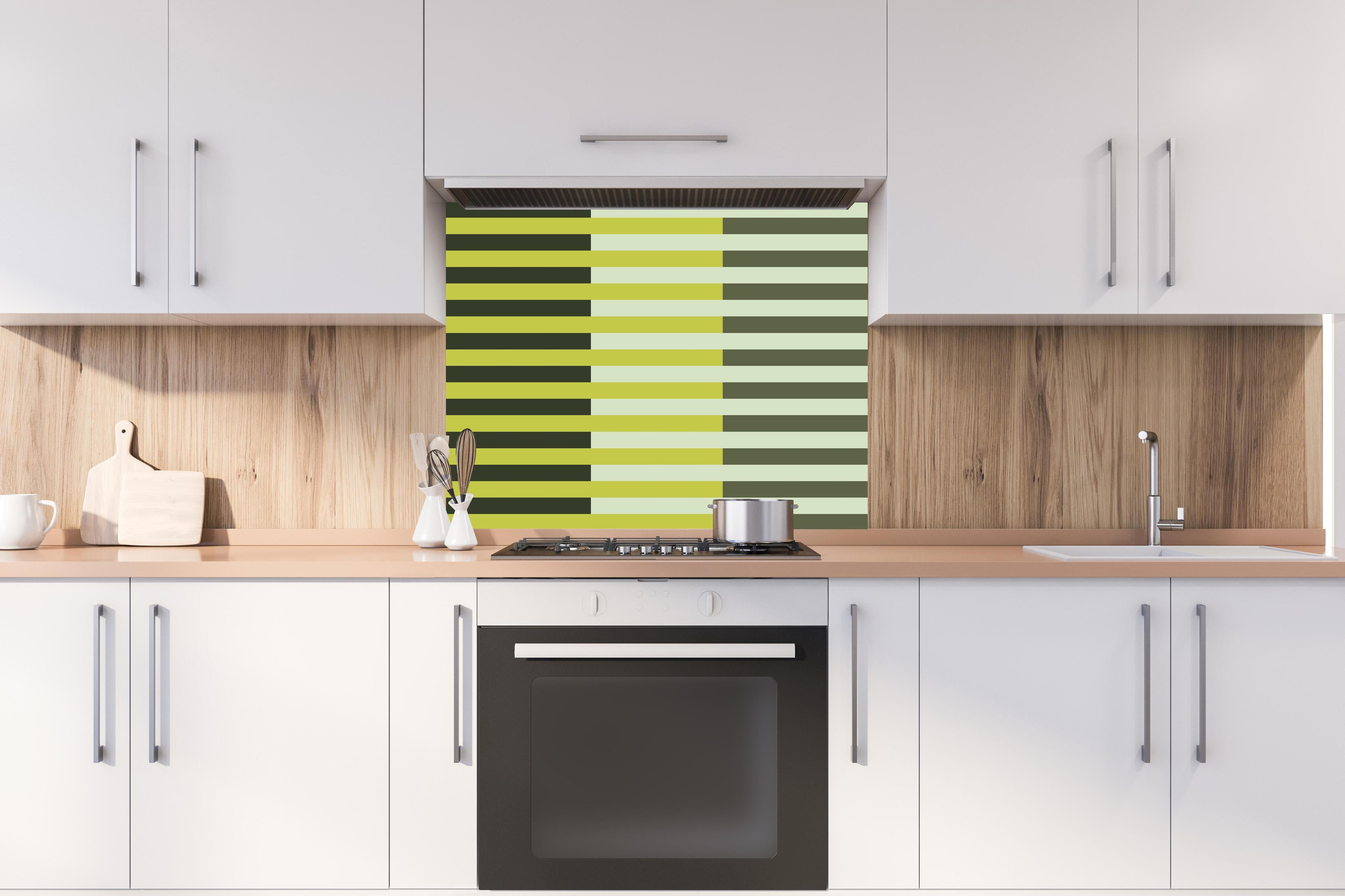 Spritzschutz - The Greens - Multy Stripes - Olive hinter einem Cerankochfeld zwischen Holz-Kochutensilien