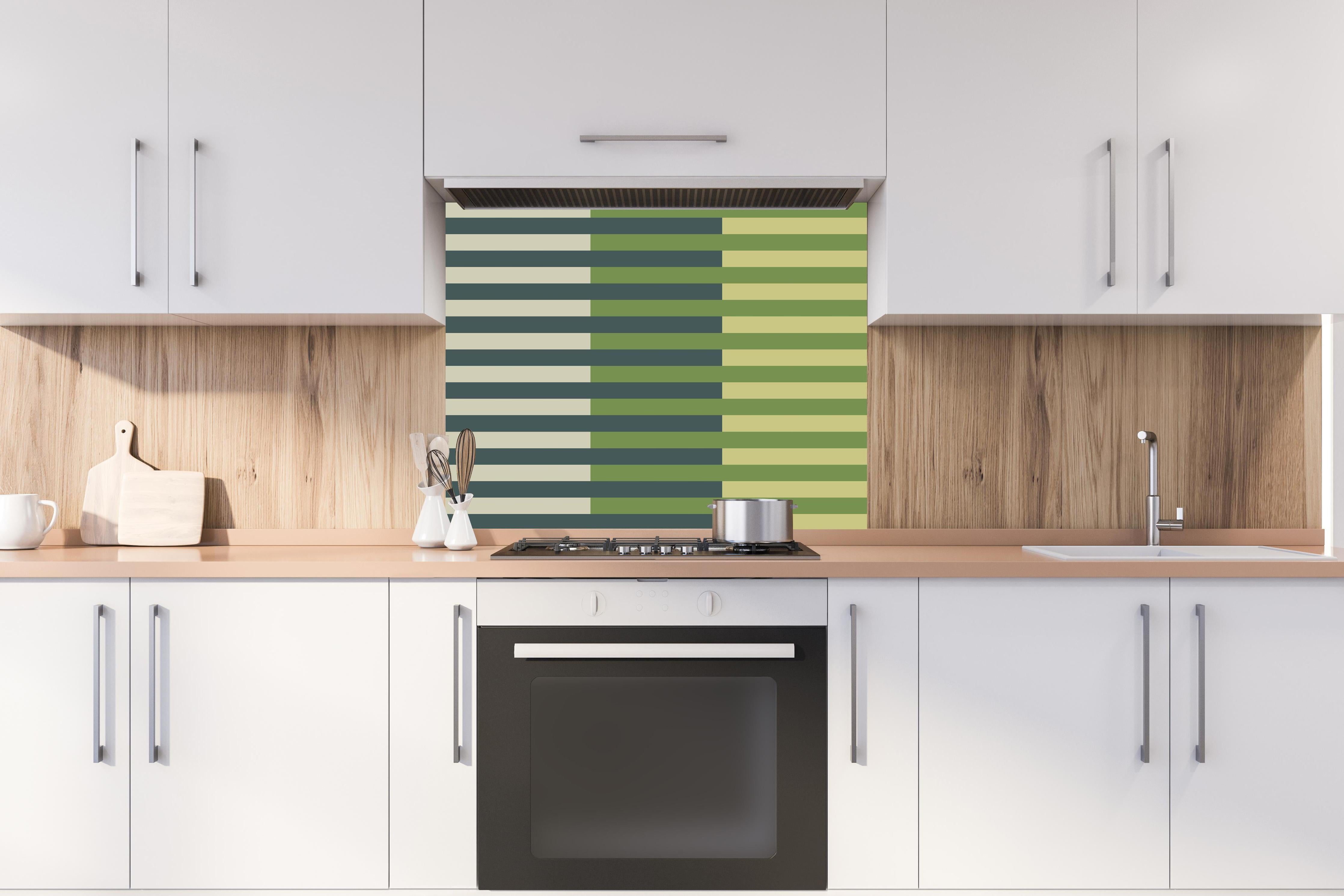 Spritzschutz - The Greens - Multy Stripes - Pistachio hinter einem Cerankochfeld zwischen Holz-Kochutensilien