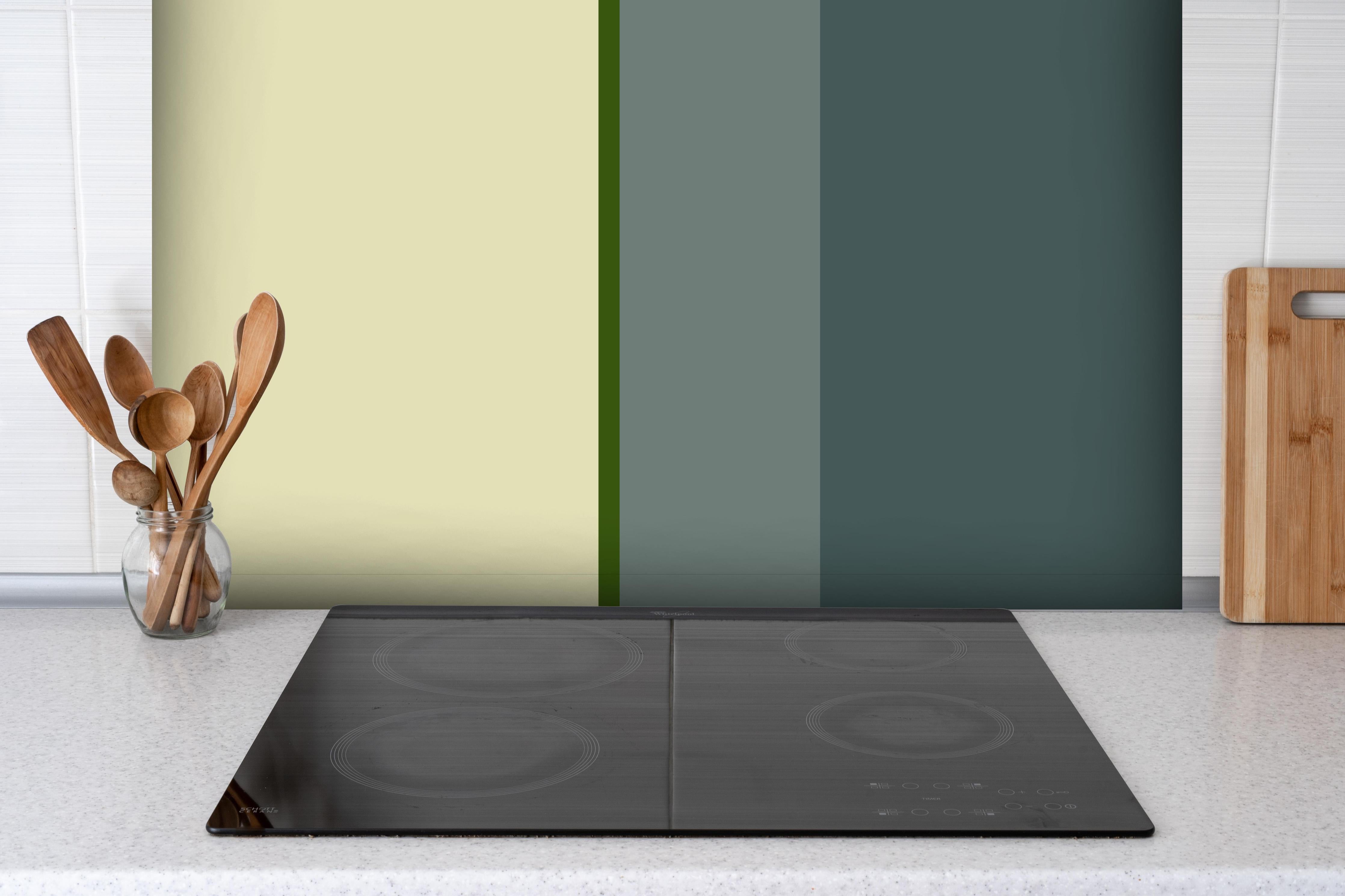 Spritzschutz - The Greens - Vertical - Avocado hinter einem Cerankochfeld zwischen Holz-Kochutensilien