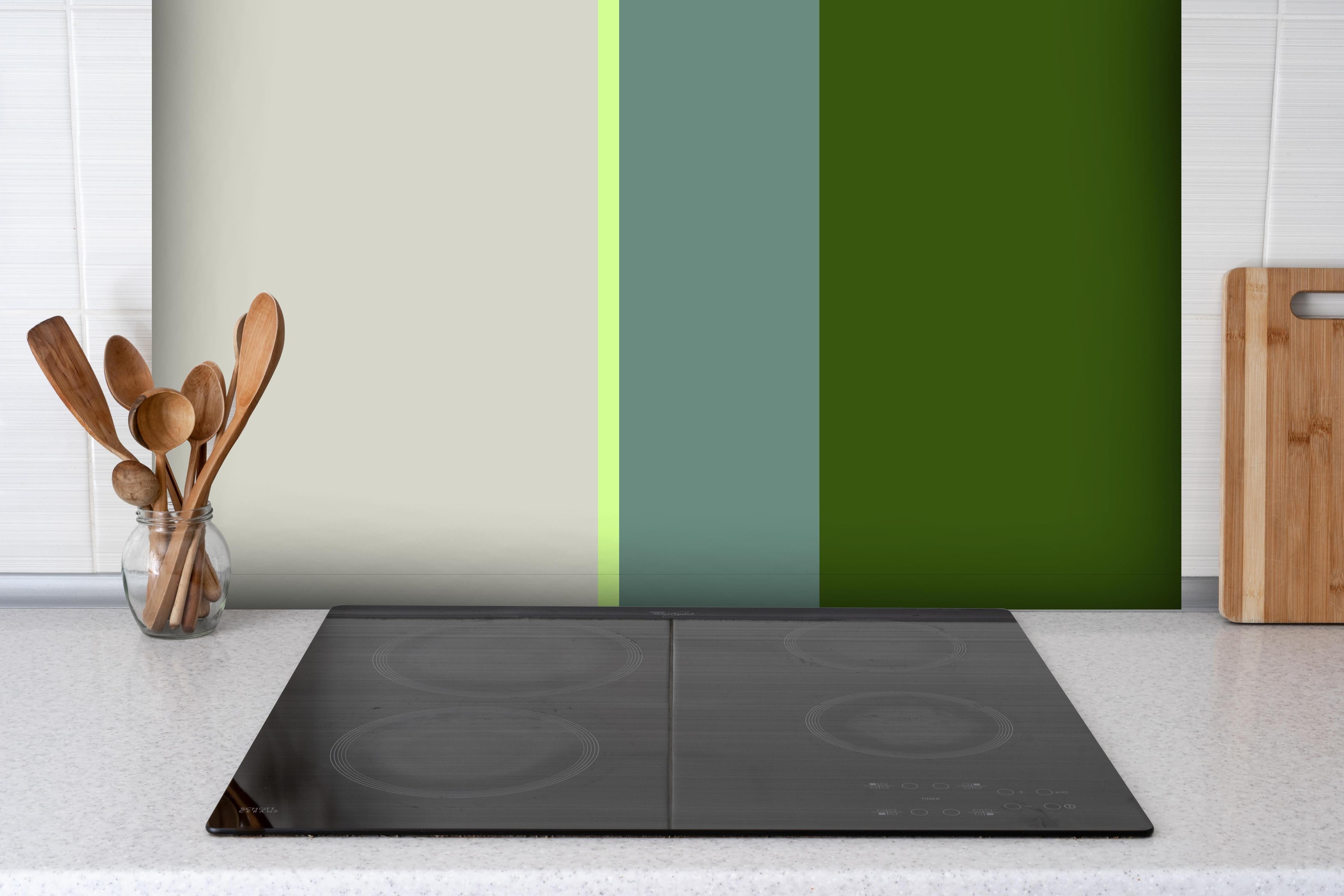 Spritzschutz - The Greens - Vertical - Granny Smith hinter einem Cerankochfeld zwischen Holz-Kochutensilien