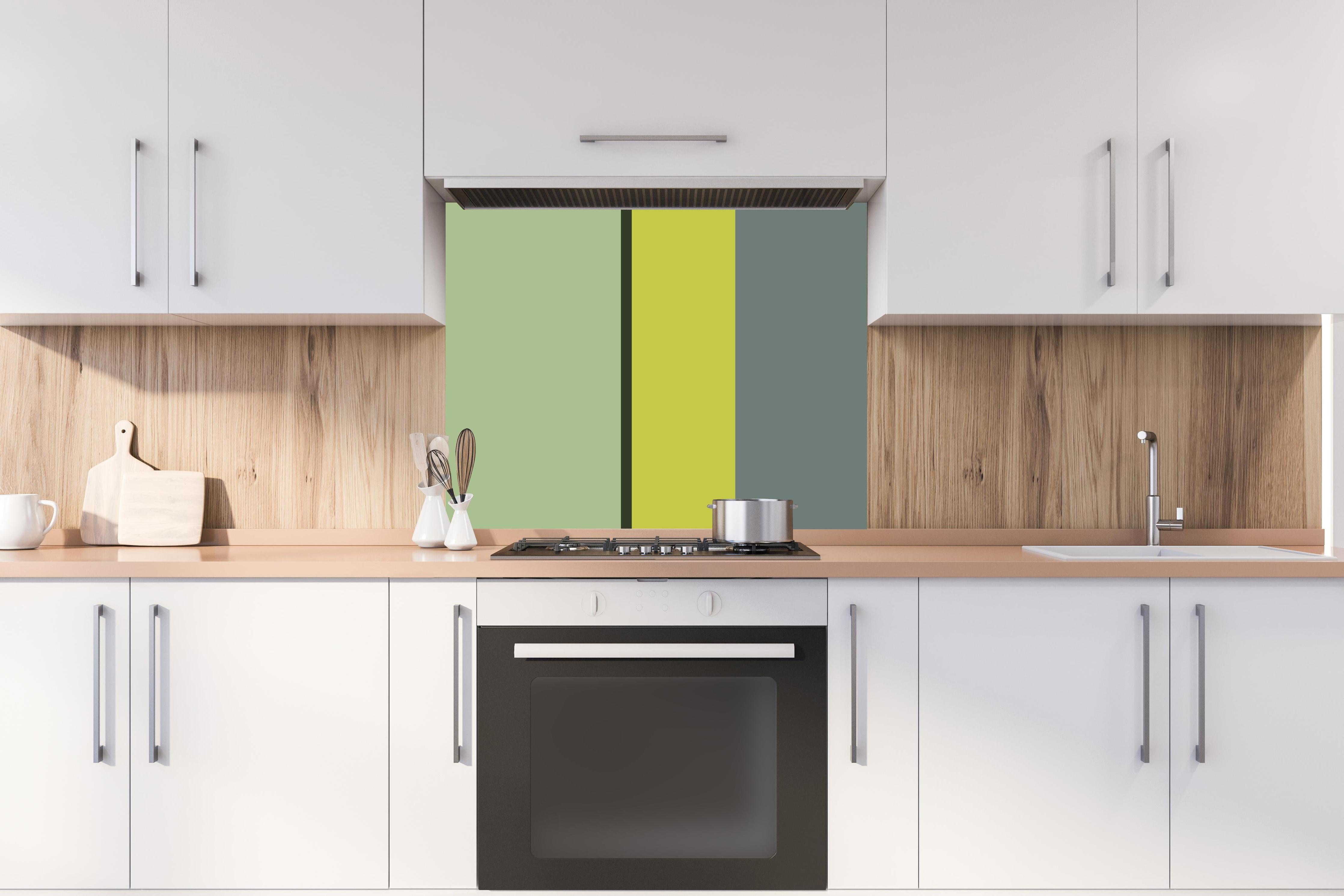 Spritzschutz - The Greens - Vertical - Matcha hinter einem Cerankochfeld zwischen Holz-Kochutensilien