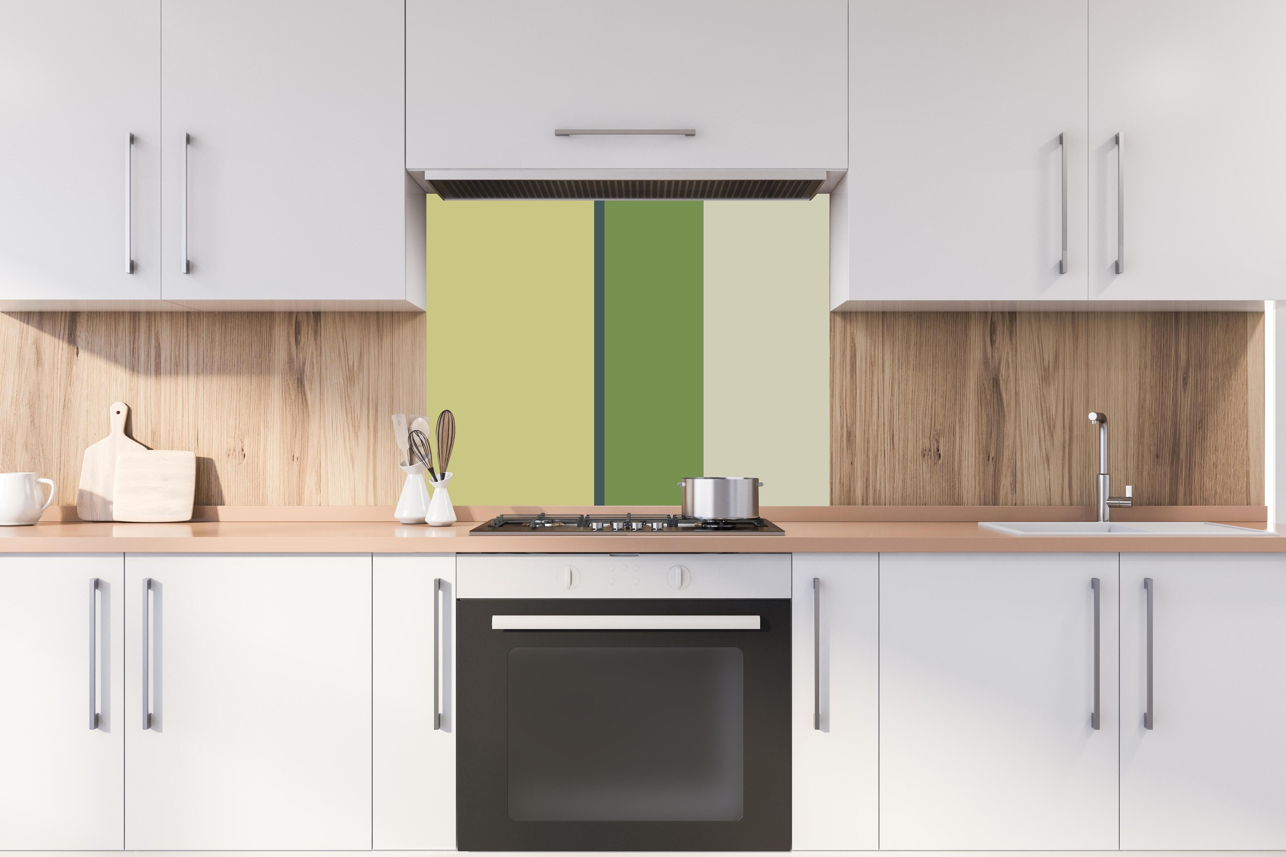 Spritzschutz - The Greens - Vertical - Pistachio hinter einem Cerankochfeld zwischen Holz-Kochutensilien