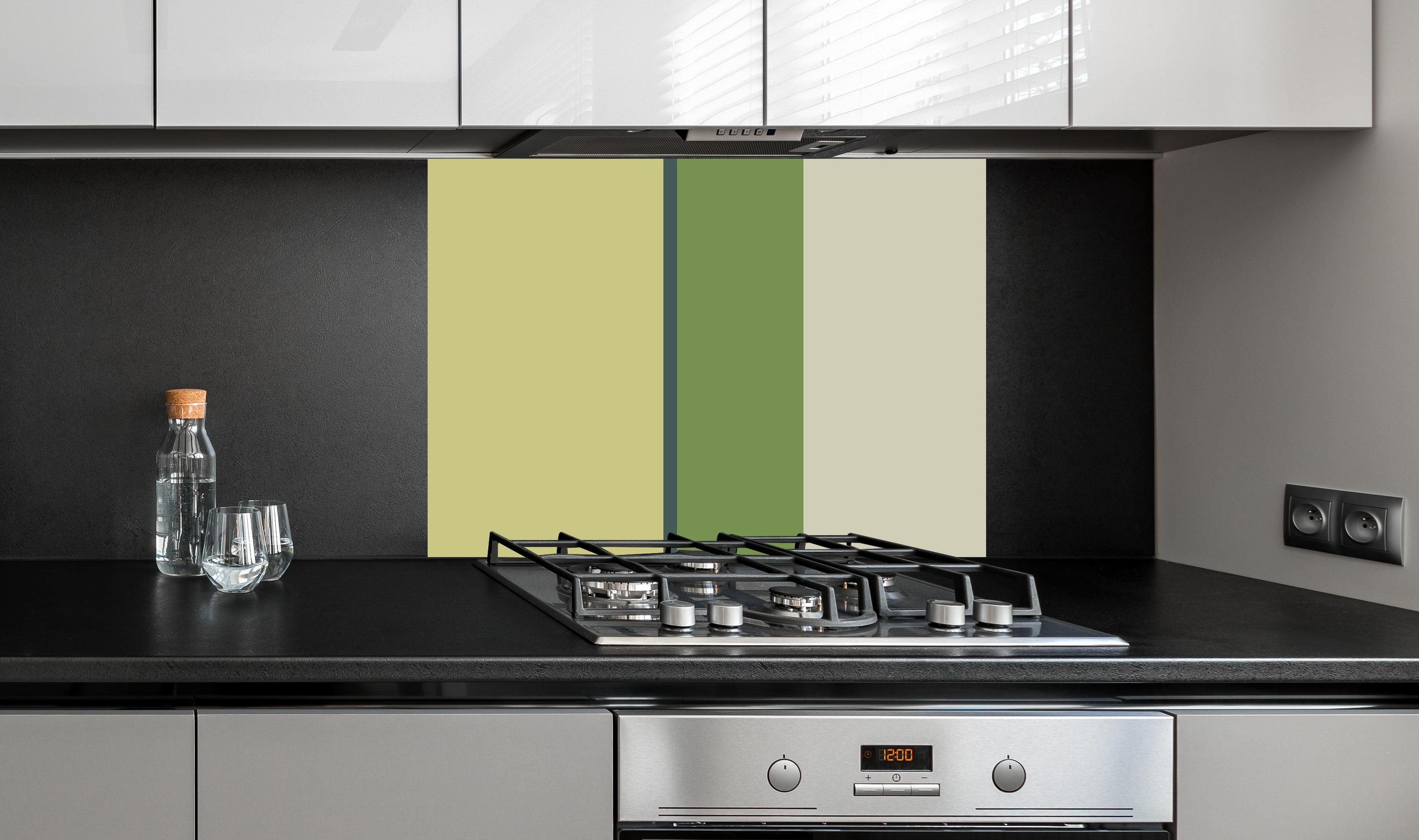 Spritzschutz - The Greens - Vertical - Pistachio hinter einem Cerankochfeld zwischen Holz-Kochutensilien