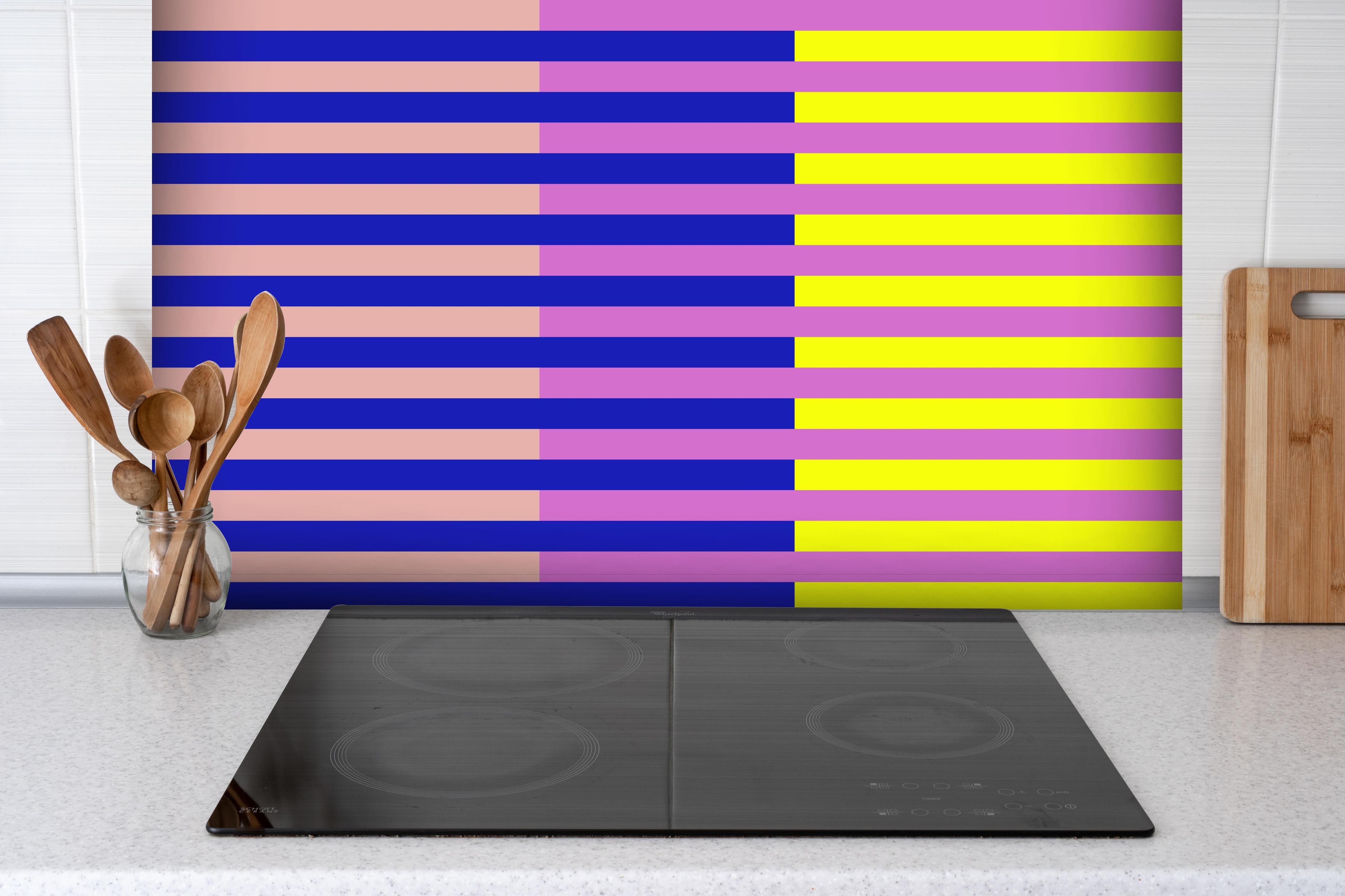 Spritzschutz - The Neons - Multy Stripes - Stellar hinter einem Cerankochfeld zwischen Holz-Kochutensilien