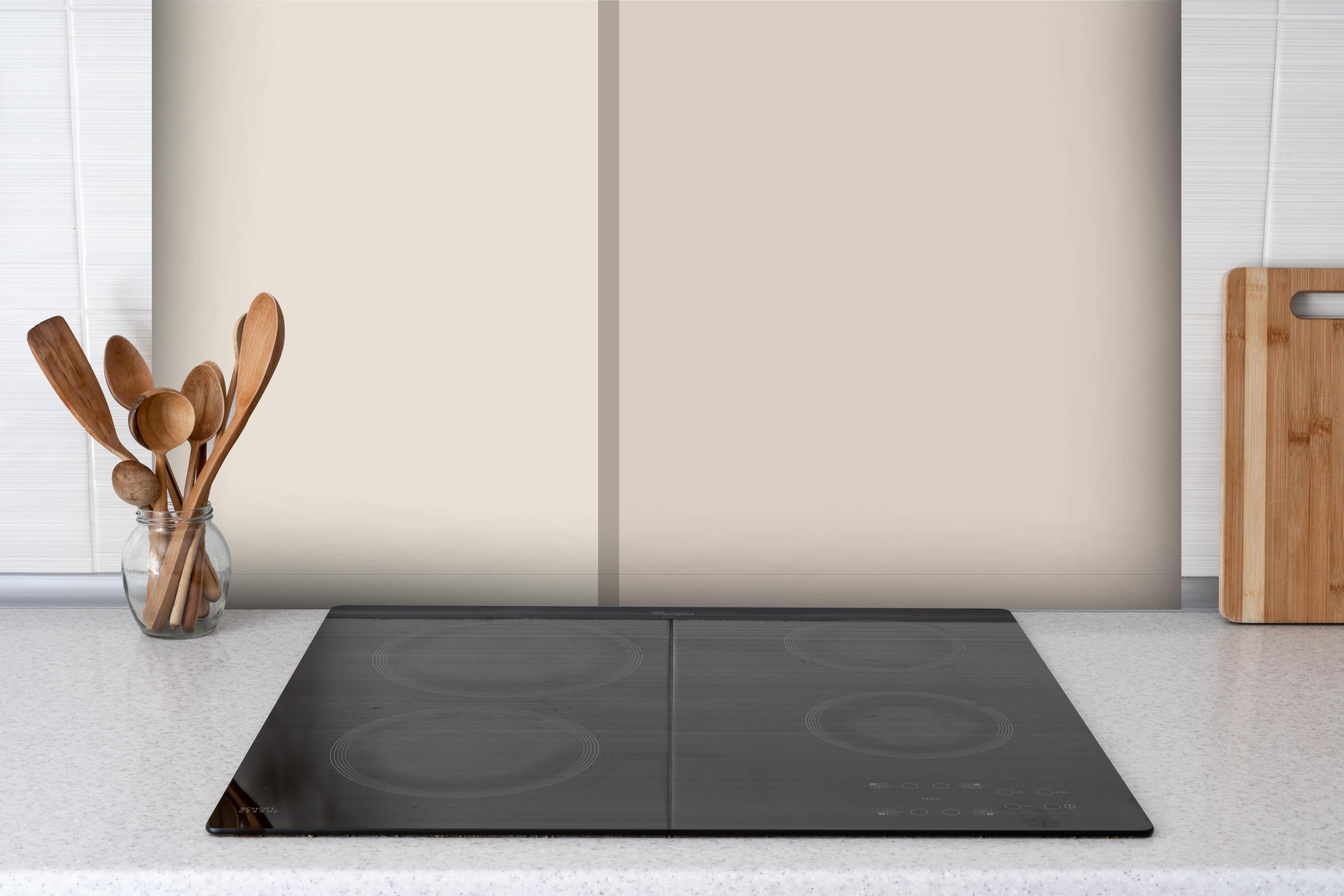 Spritzschutz - The Nudes - Easy Vertikal - Caramel hinter einem Cerankochfeld zwischen Holz-Kochutensilien