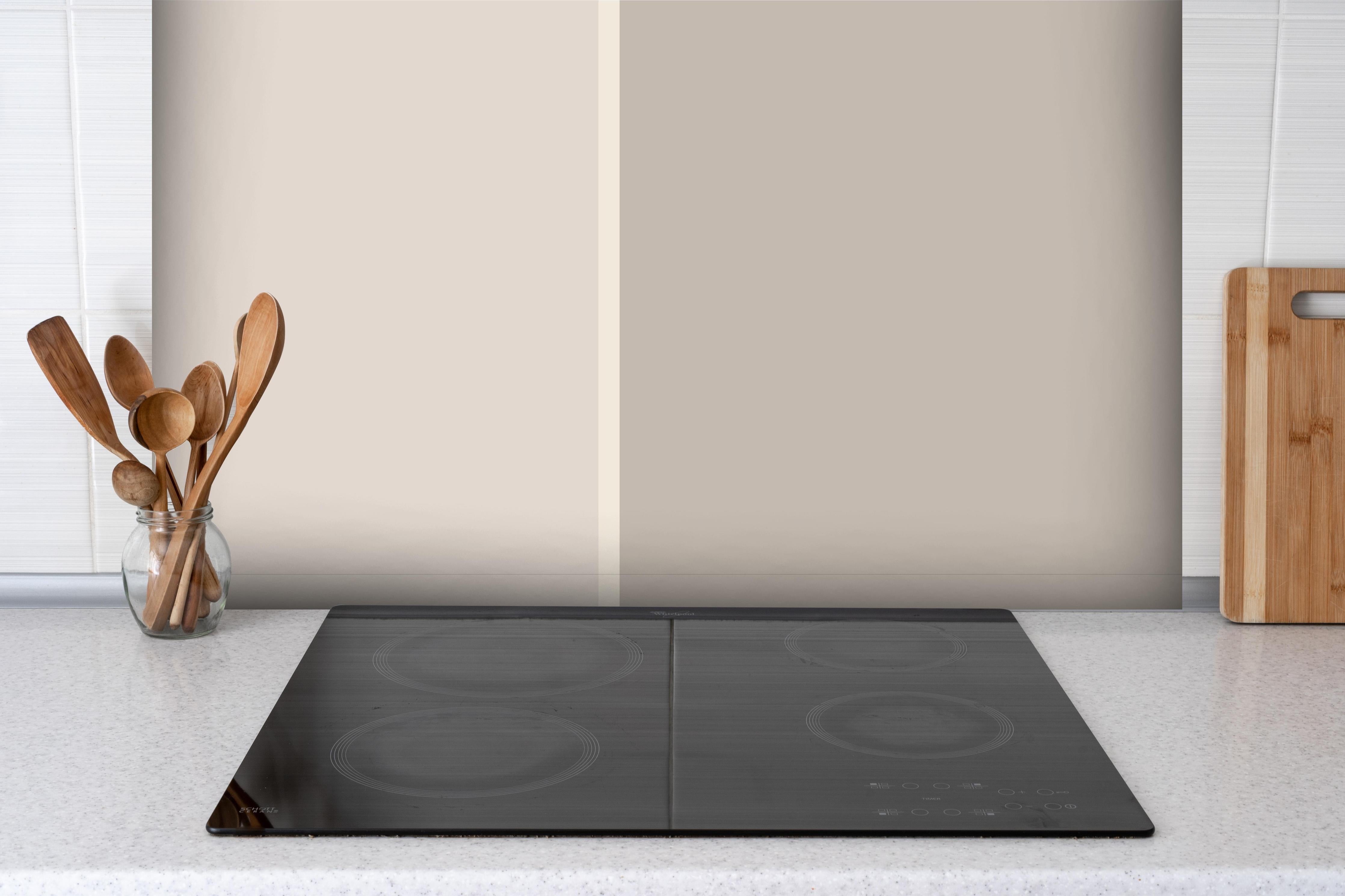 Spritzschutz - The Nudes - Easy Vertikal - Latte hinter einem Cerankochfeld zwischen Holz-Kochutensilien