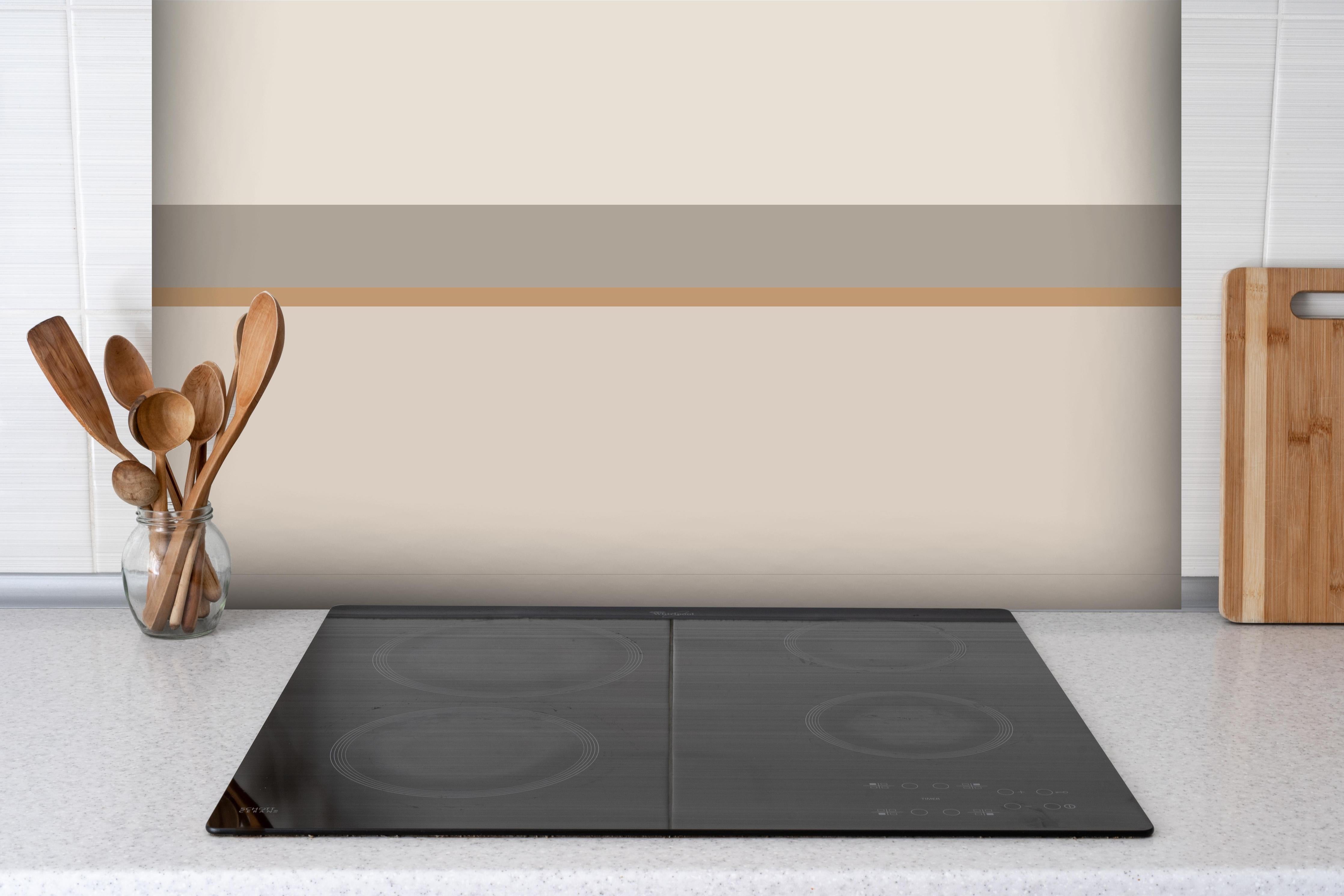 Spritzschutz - The Nudes - Horizontal - Caramel hinter einem Cerankochfeld zwischen Holz-Kochutensilien