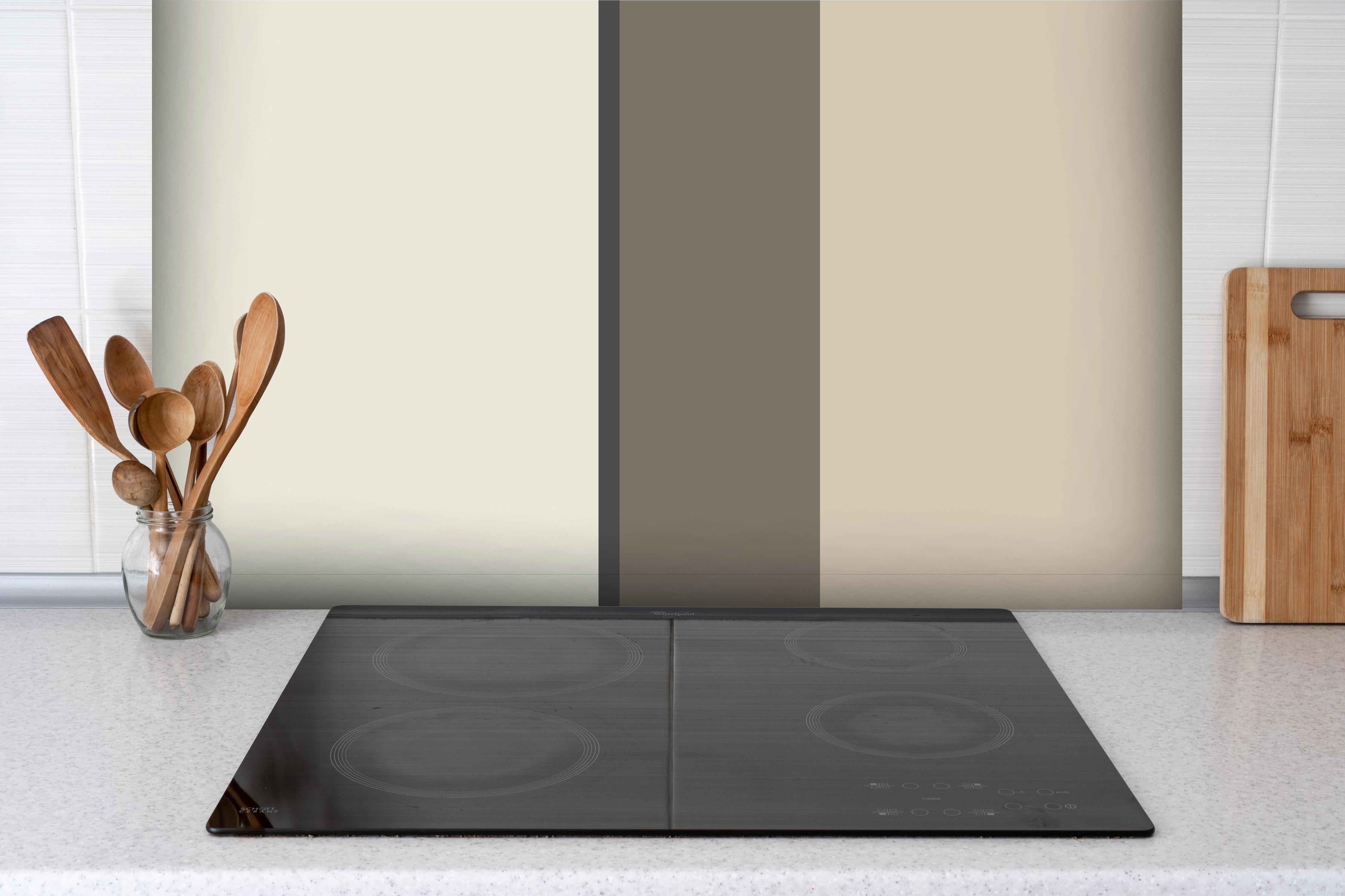 Spritzschutz - The Nudes - Vertikal - Toffee hinter einem Cerankochfeld zwischen Holz-Kochutensilien