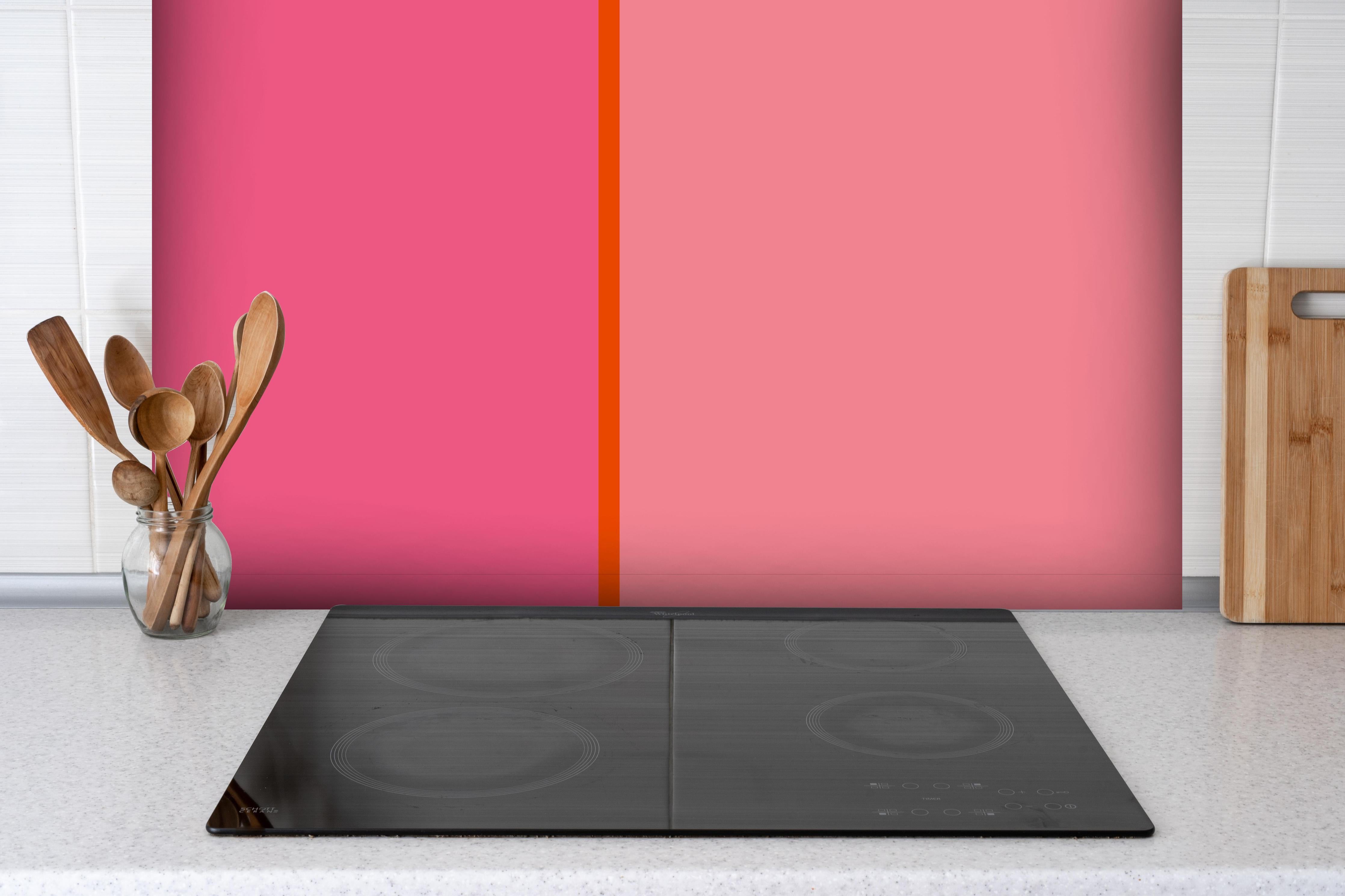 Spritzschutz - The Oranges - Easy Vertical - Raspberry hinter einem Cerankochfeld zwischen Holz-Kochutensilien