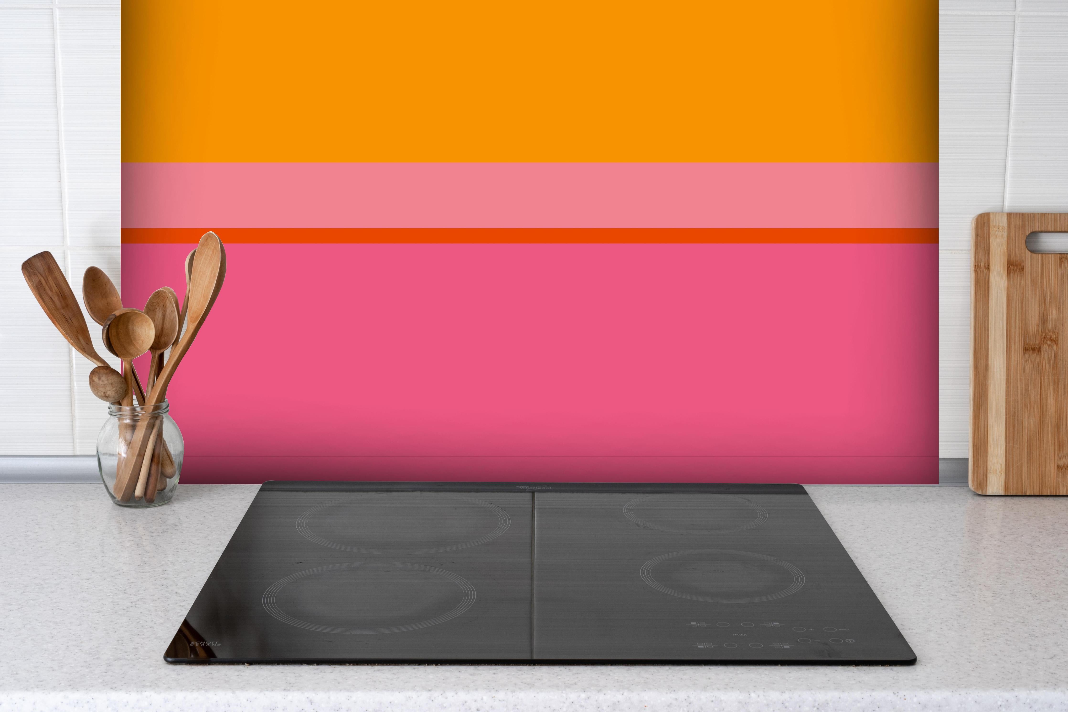 Spritzschutz - The Oranges - Horizontal - Raspberry hinter einem Cerankochfeld zwischen Holz-Kochutensilien