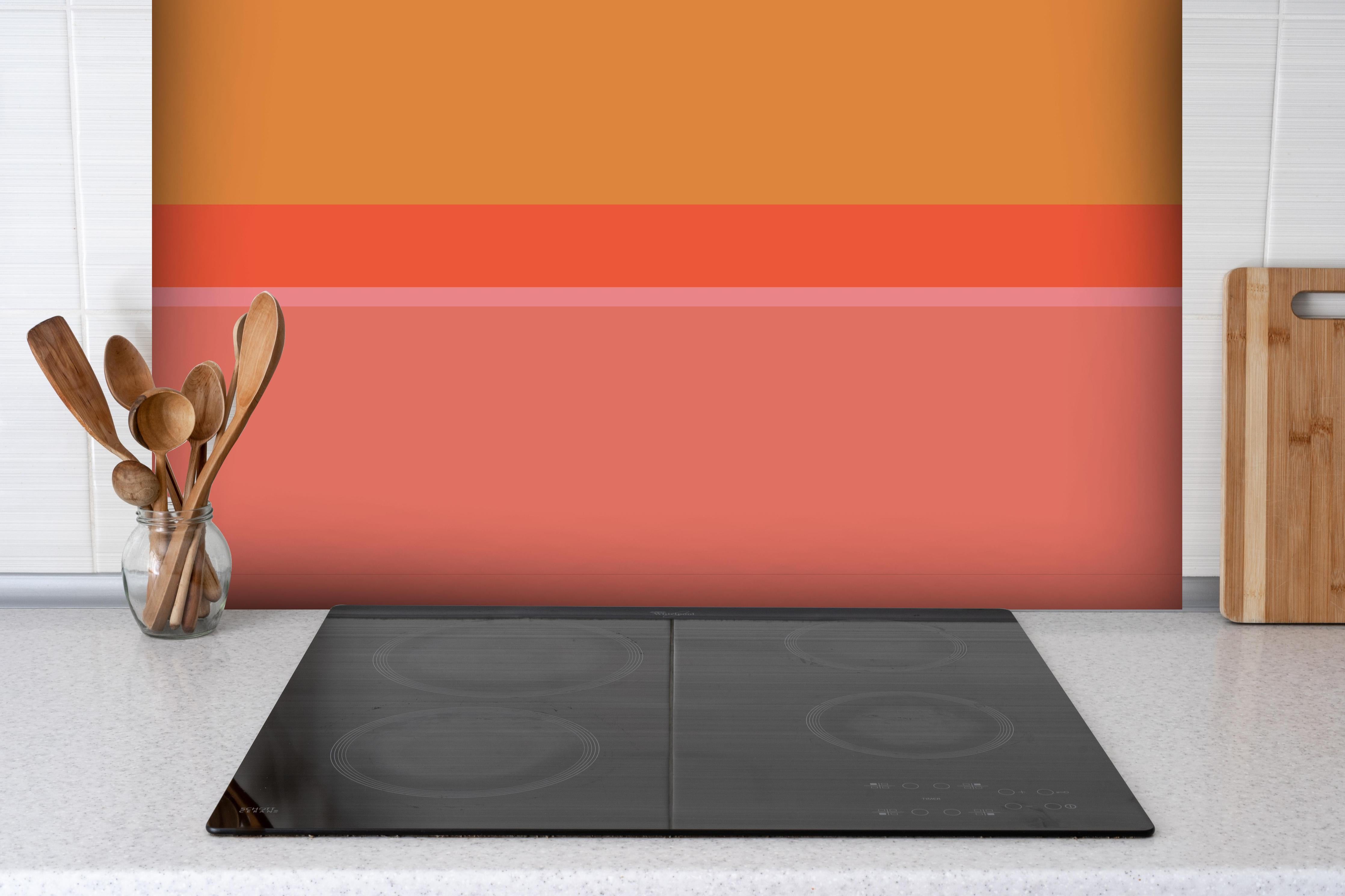 Spritzschutz - The Oranges - Horizontal - Salmon hinter einem Cerankochfeld zwischen Holz-Kochutensilien