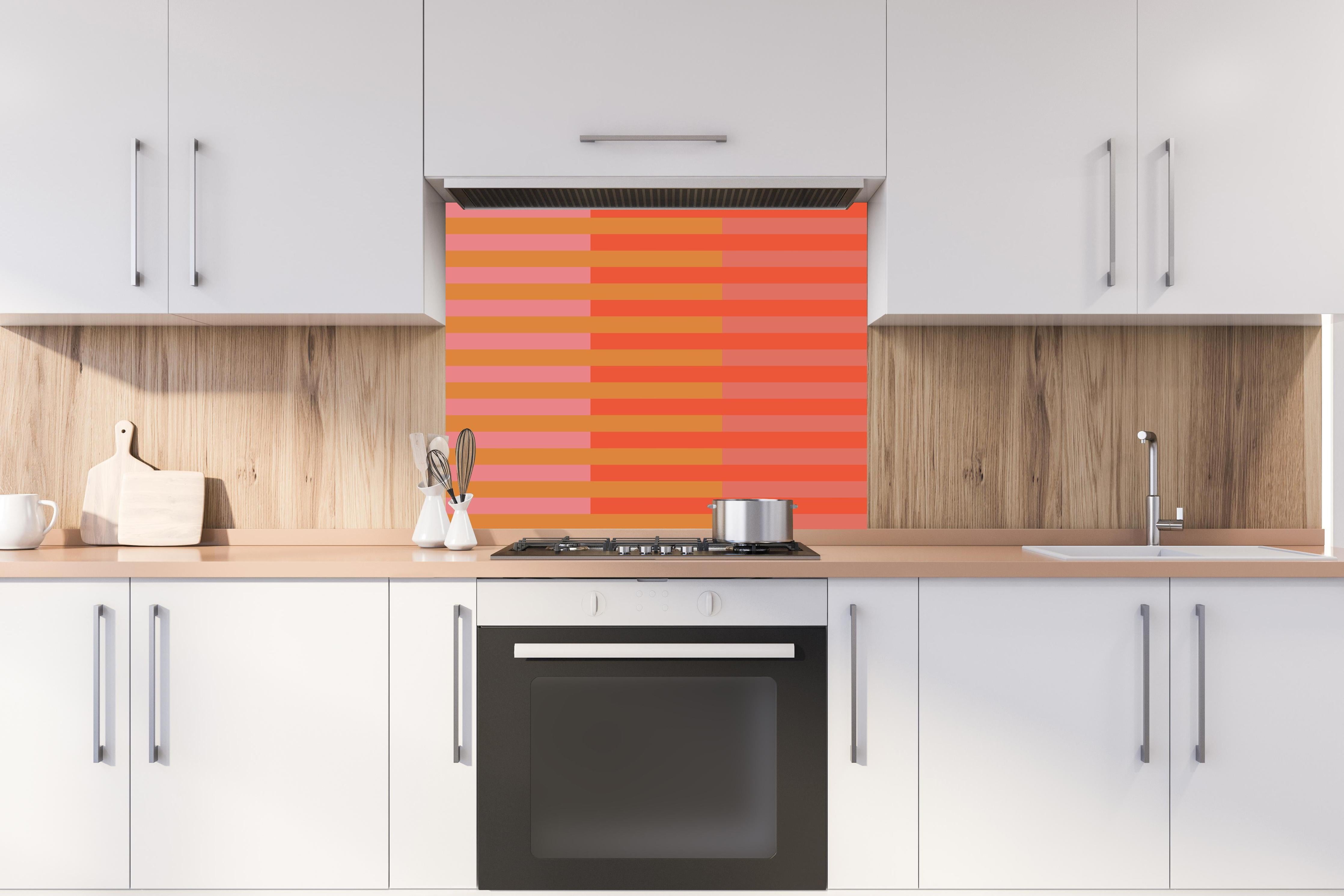 Spritzschutz - The Oranges - Multy Stripes - Salmon hinter einem Cerankochfeld zwischen Holz-Kochutensilien