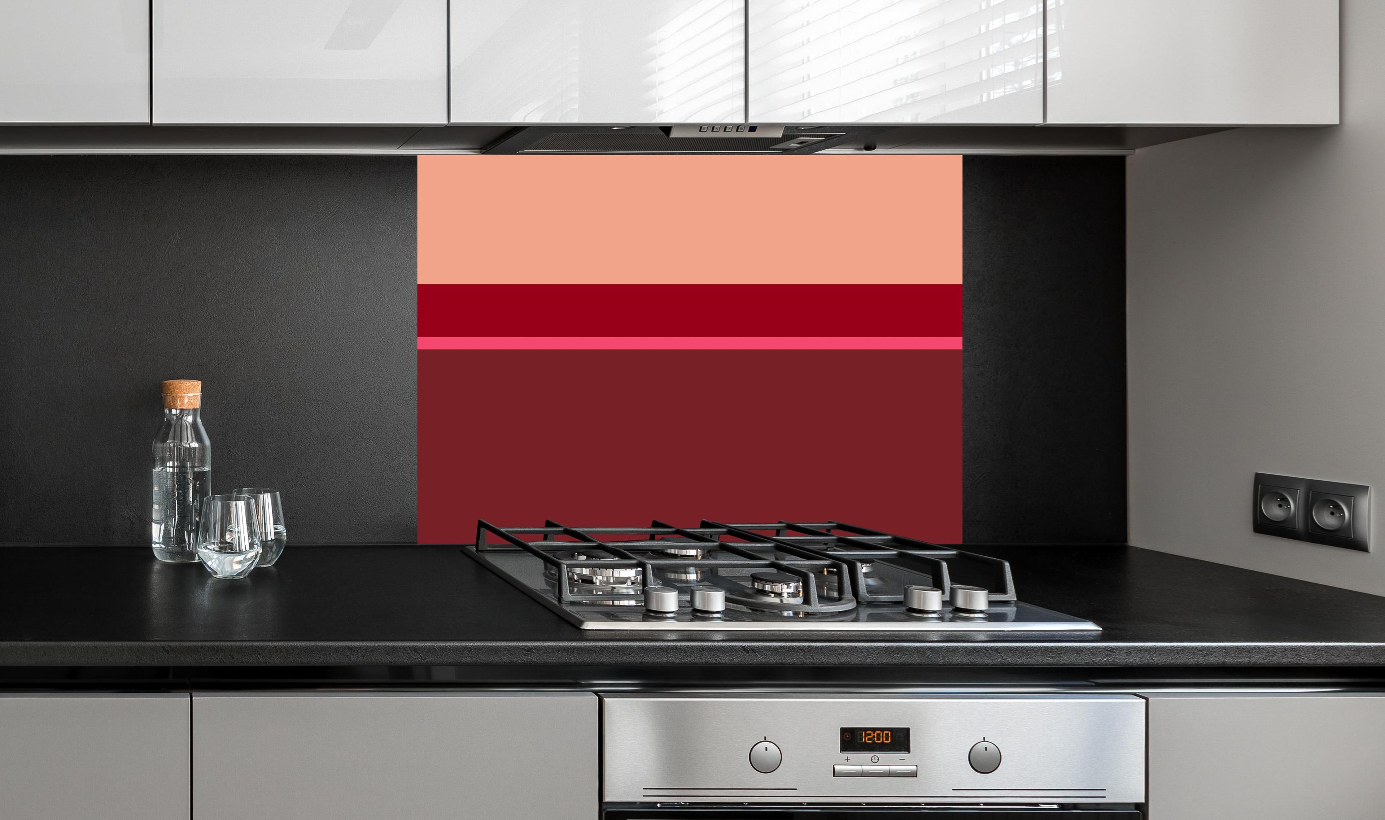 Spritzschutz - The Reds - Horizontal - Cherry hinter einem Cerankochfeld zwischen Holz-Kochutensilien