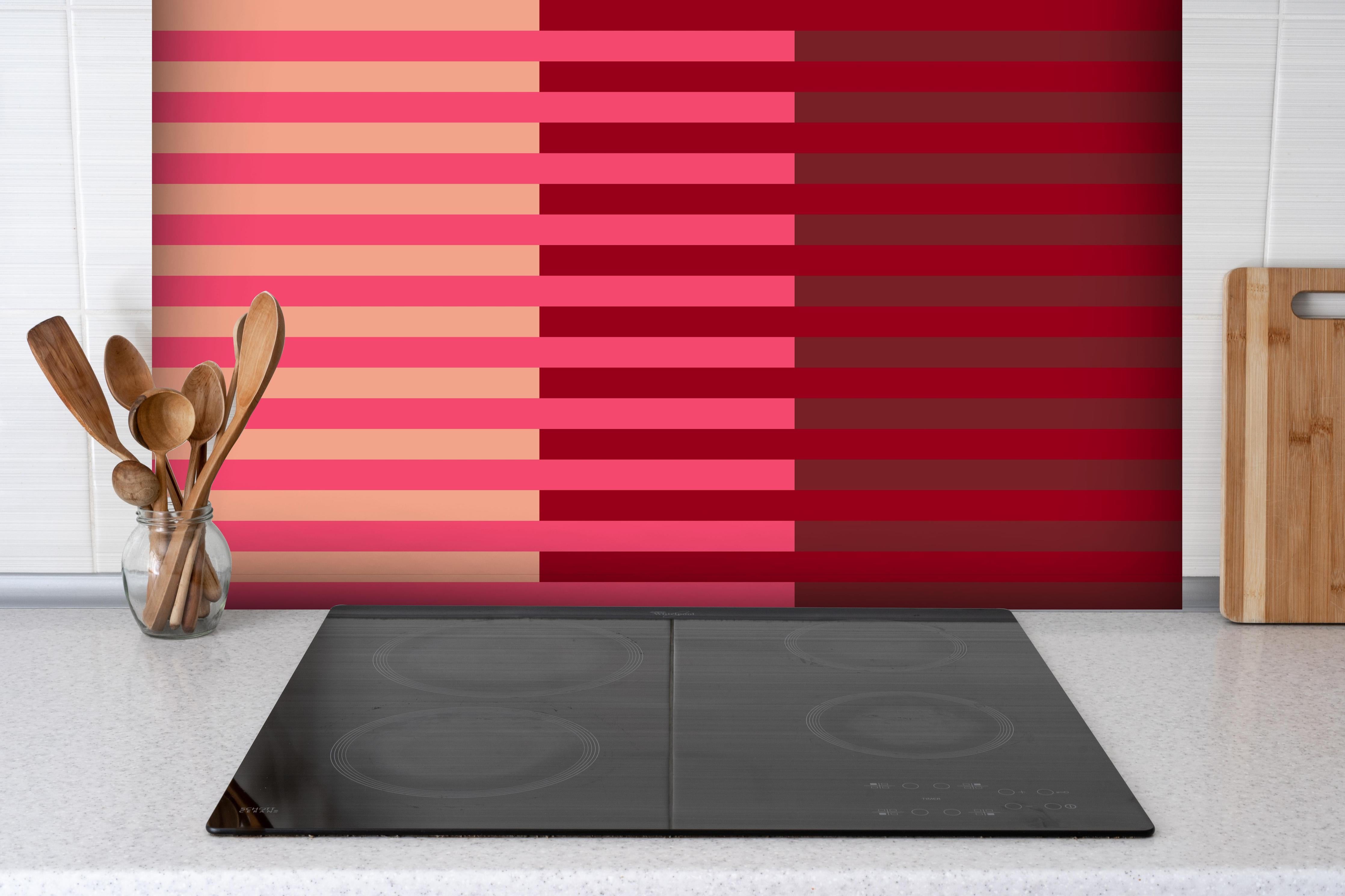 Spritzschutz - The Reds - Multy Stripes - Cherry hinter einem Cerankochfeld zwischen Holz-Kochutensilien