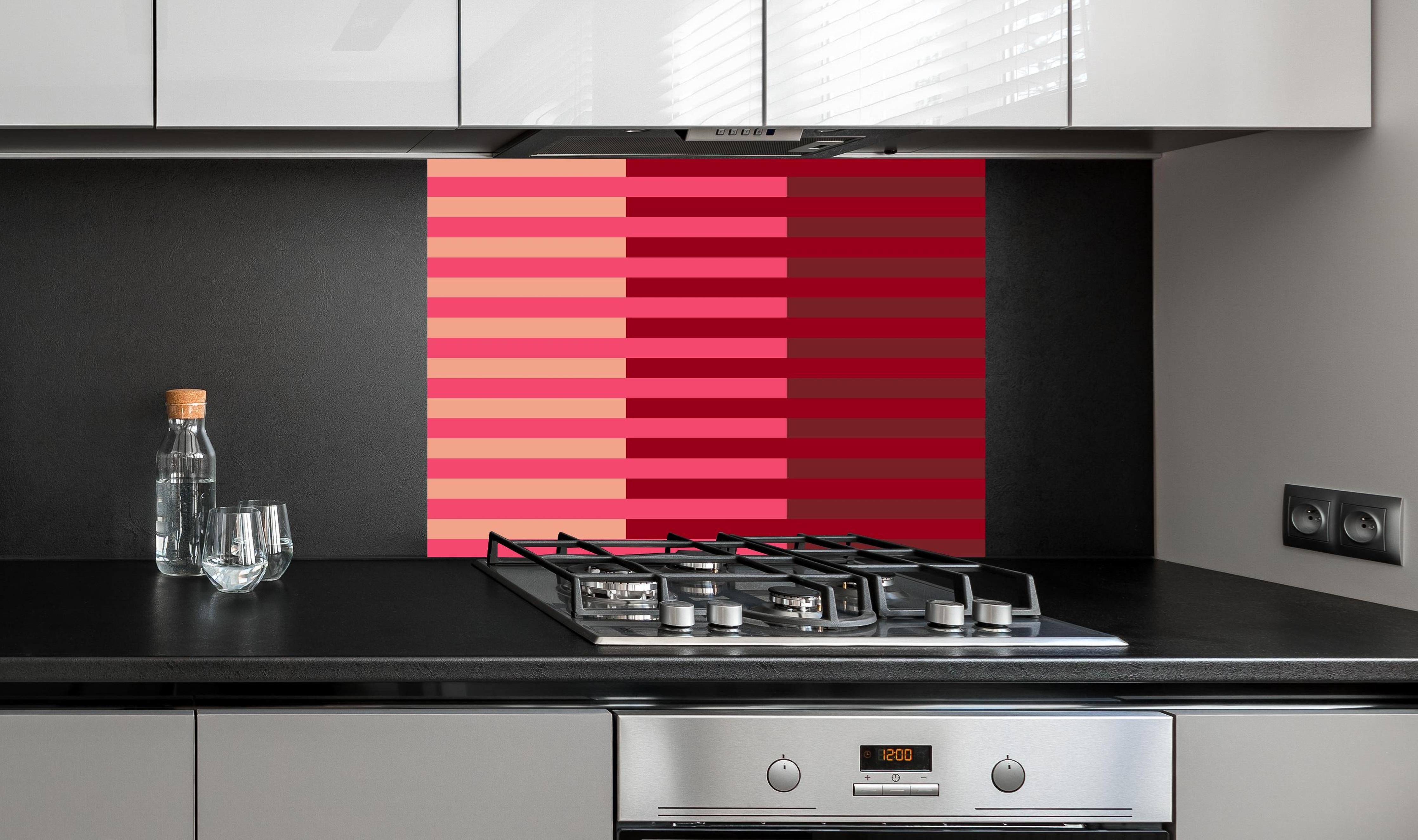 Spritzschutz - The Reds - Multy Stripes - Cherry hinter einem Cerankochfeld zwischen Holz-Kochutensilien