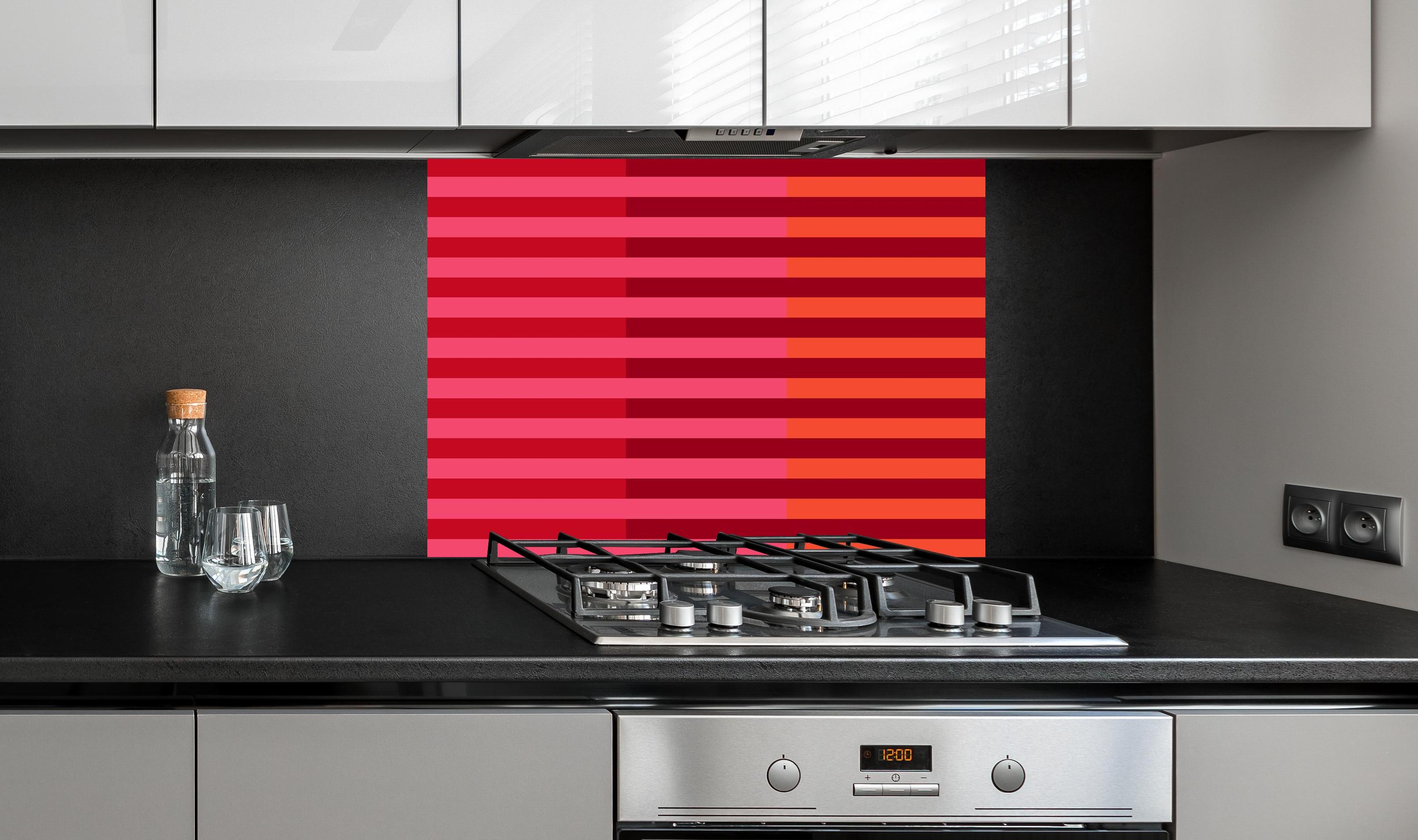 Spritzschutz - The Reds - Multy Stripes - Pomegranate hinter einem Cerankochfeld zwischen Holz-Kochutensilien