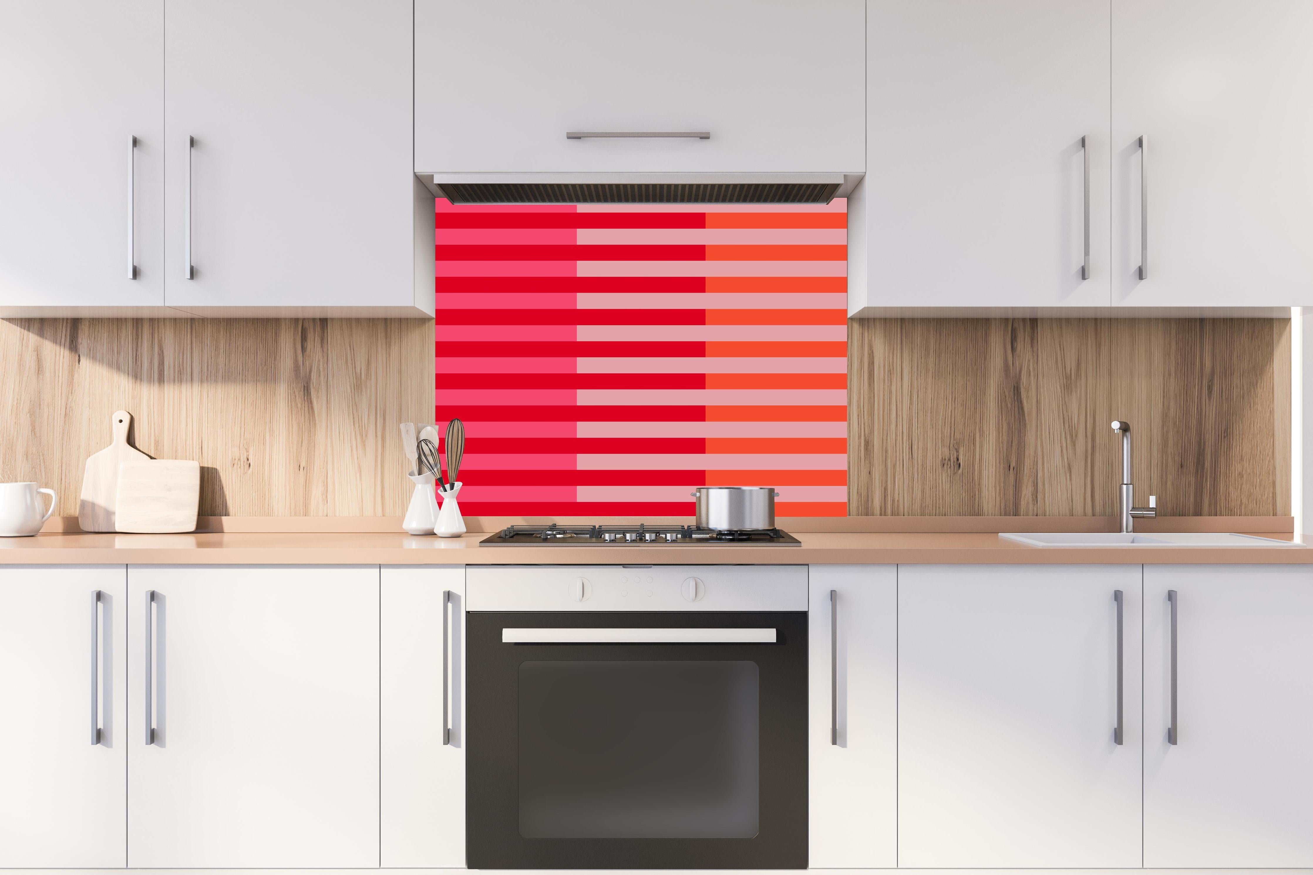 Spritzschutz - The Reds - Multy Stripes - Strawberry hinter einem Cerankochfeld zwischen Holz-Kochutensilien