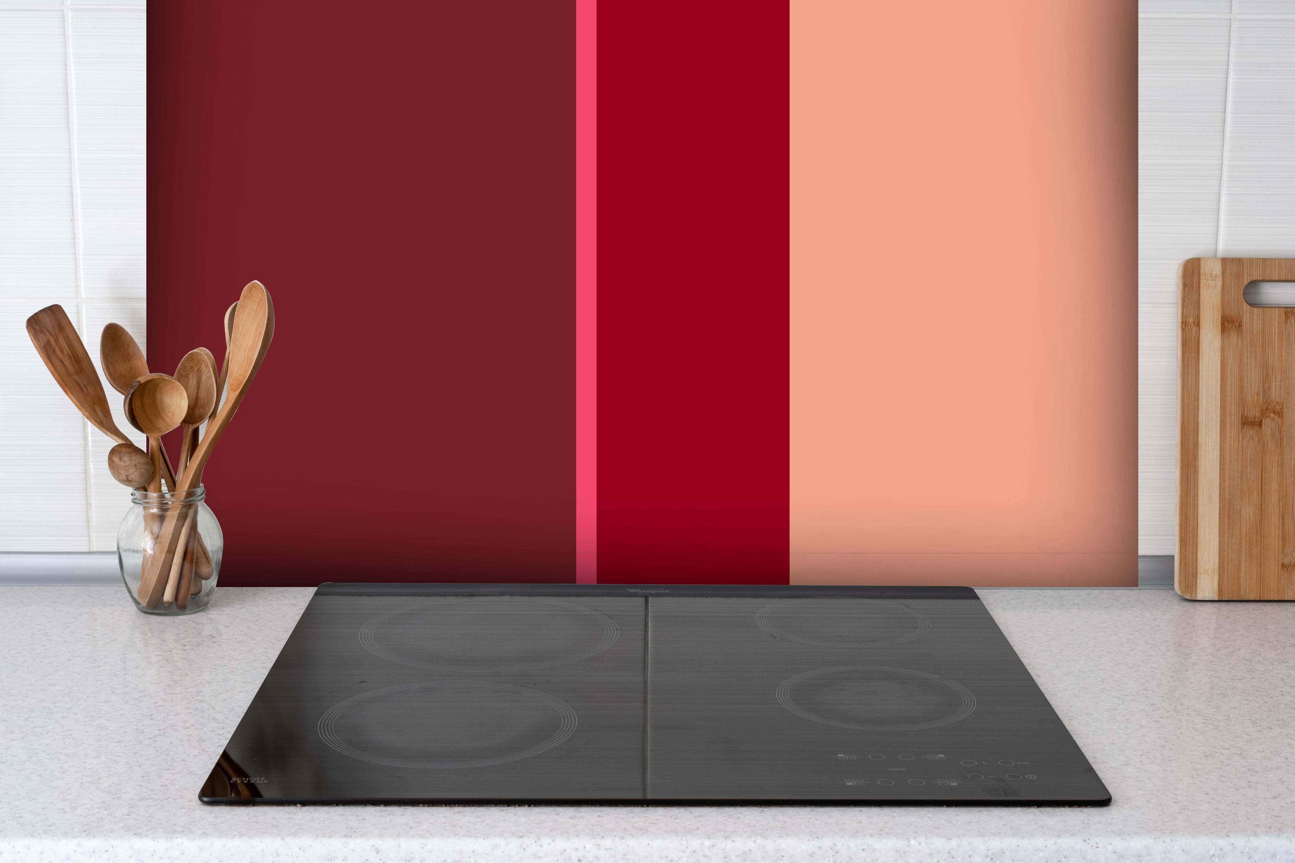 Spritzschutz - The Reds - Vertical - Cherry hinter einem Cerankochfeld zwischen Holz-Kochutensilien