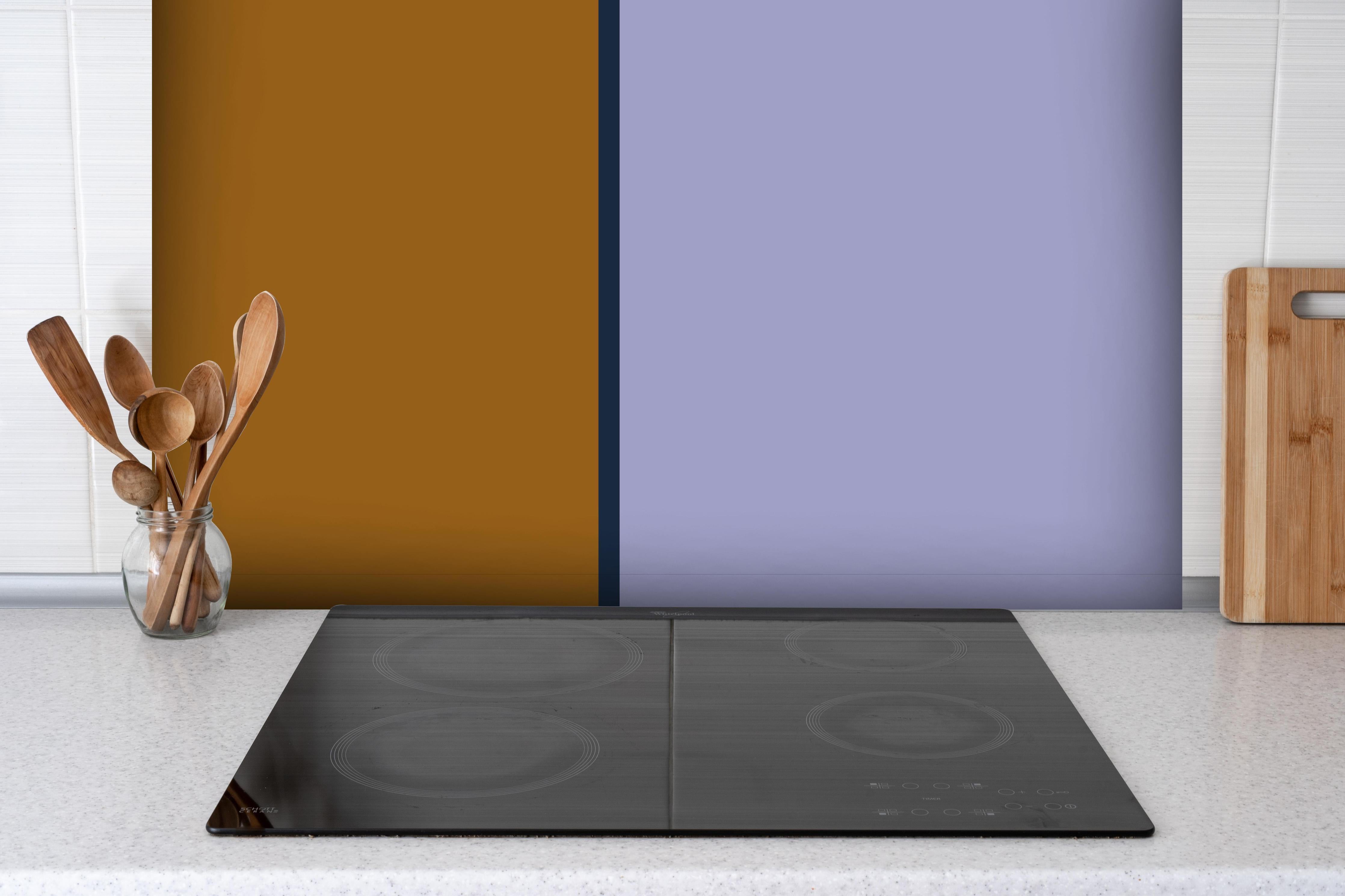 Spritzschutz - The Retros - Easy Vertikal - Tyrion hinter einem Cerankochfeld zwischen Holz-Kochutensilien