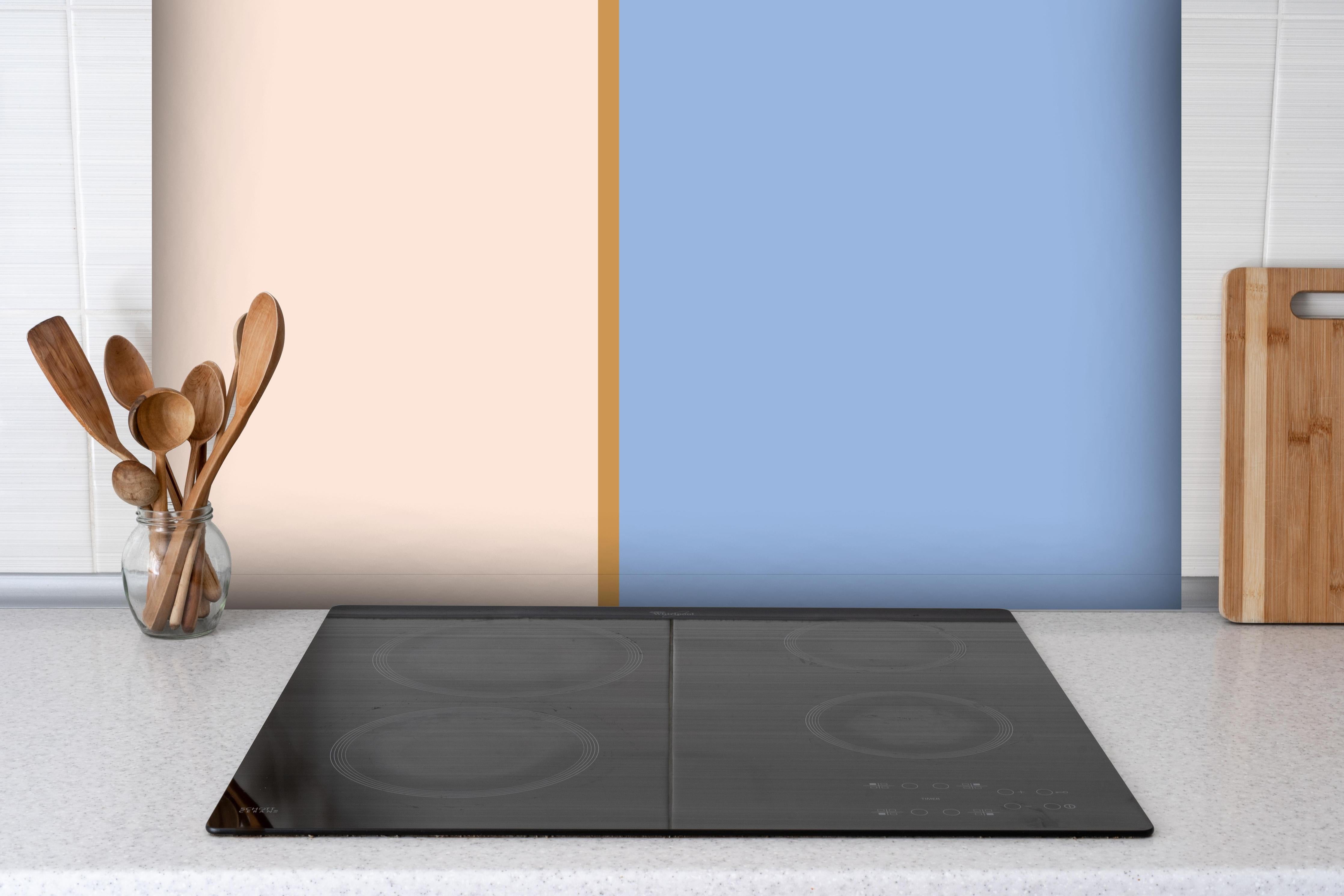 Spritzschutz - The Vintages - Easy Vertikal - Eloise hinter einem Cerankochfeld zwischen Holz-Kochutensilien