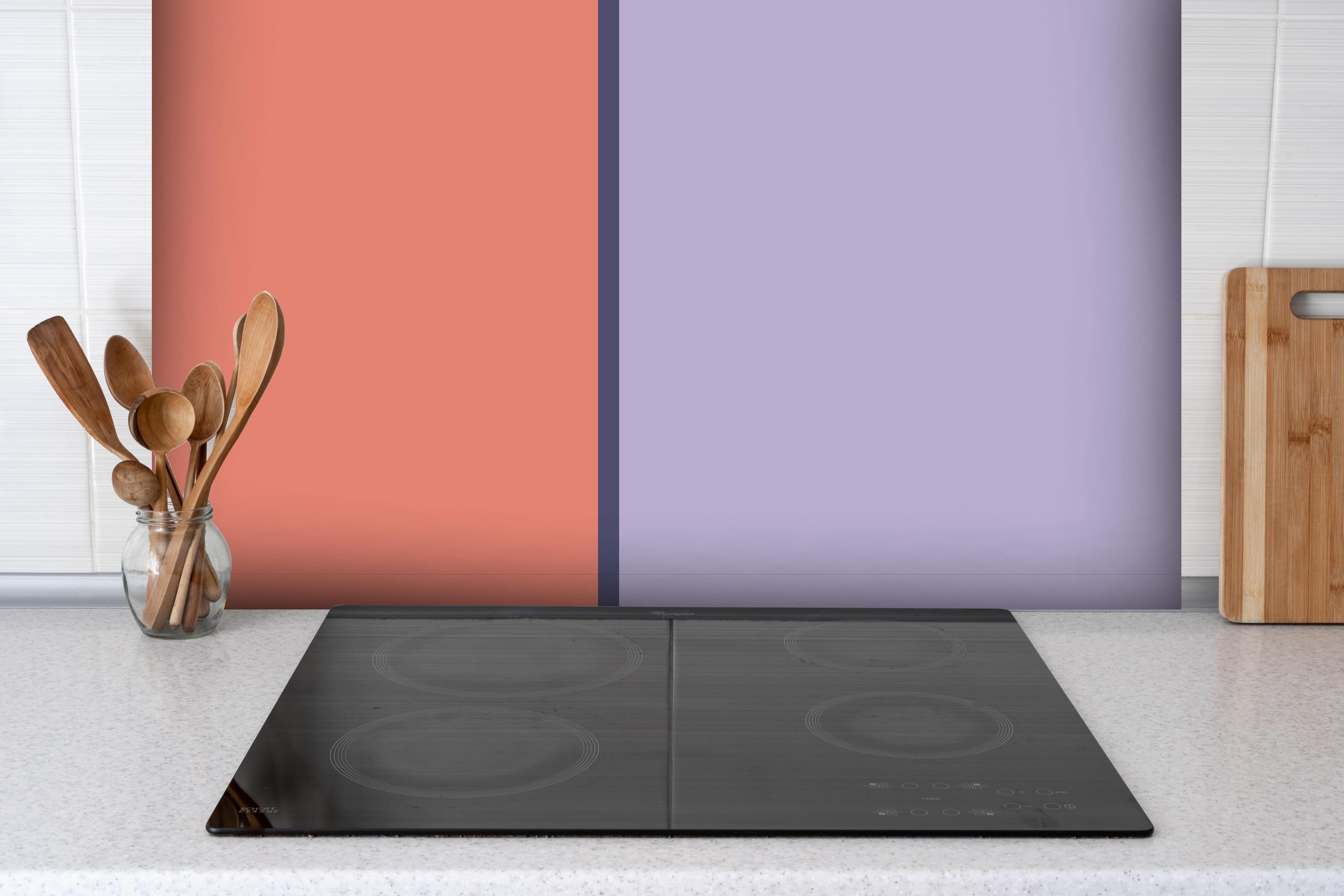 Spritzschutz - The Vintages - Easy Vertikal - Penelope hinter einem Cerankochfeld zwischen Holz-Kochutensilien