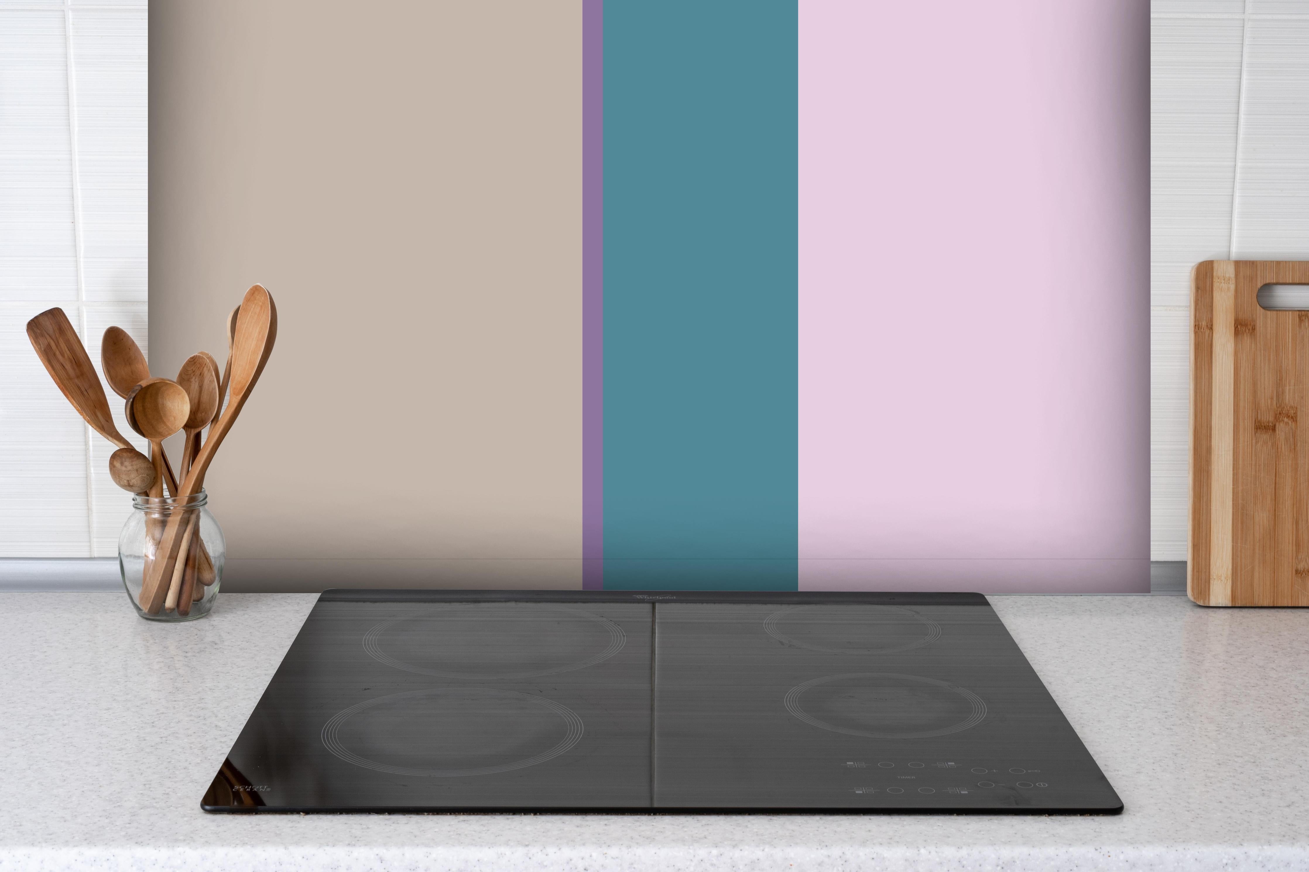 Spritzschutz - The Vintages - Vertikal - Daphne hinter einem Cerankochfeld zwischen Holz-Kochutensilien