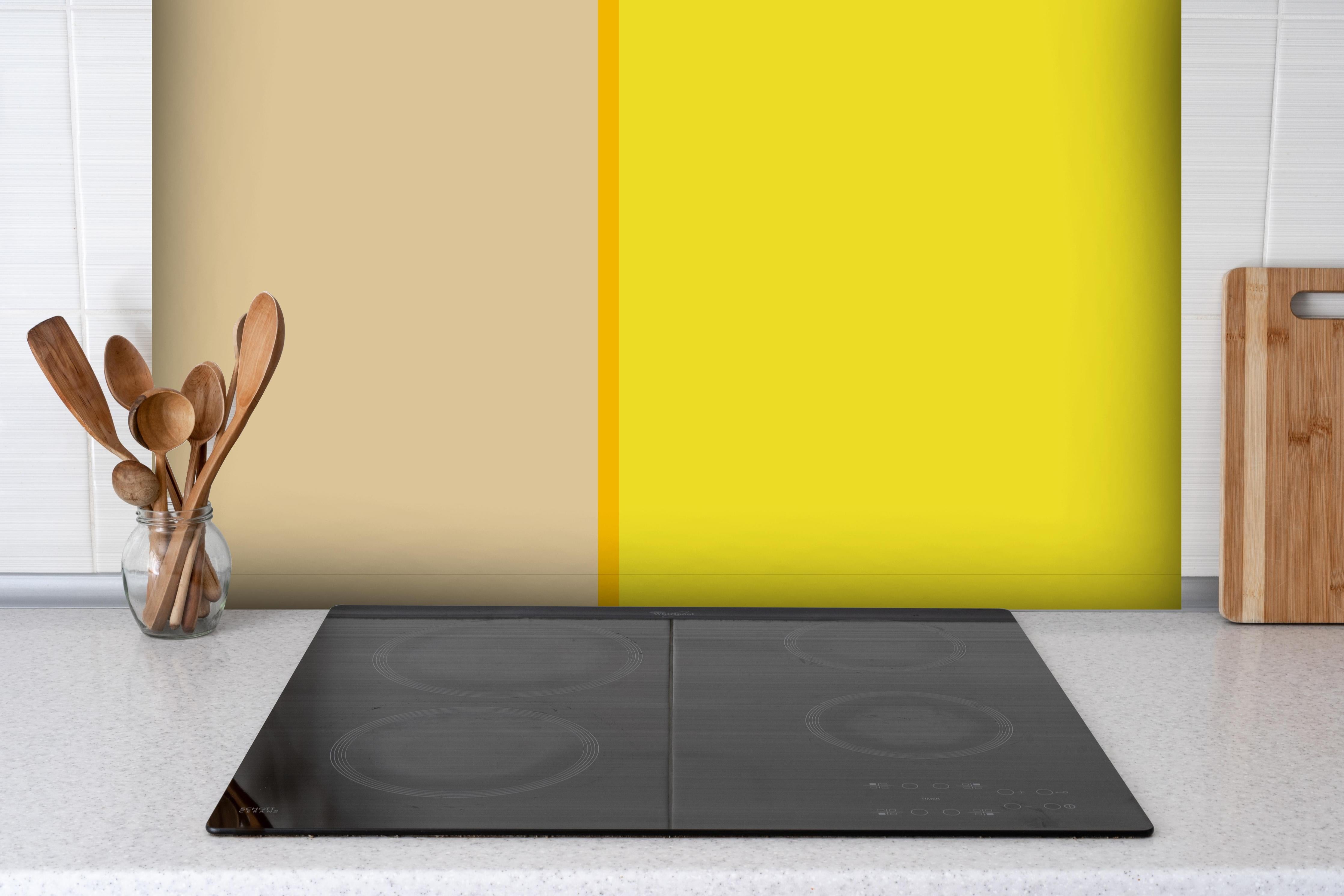Spritzschutz - The Yellows - Easy Vertical - Honey hinter einem Cerankochfeld zwischen Holz-Kochutensilien
