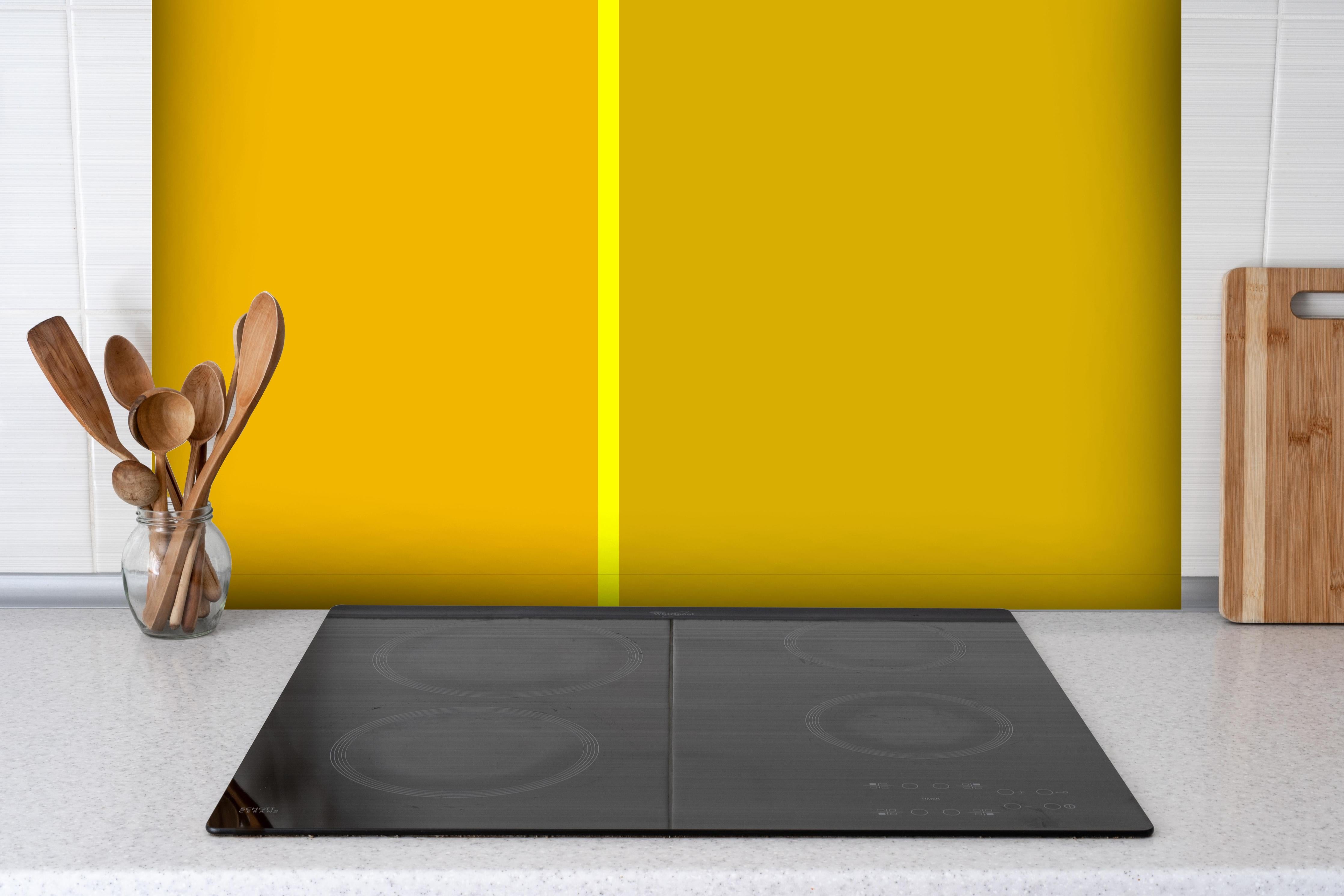 Spritzschutz - The Yellows - Easy Vertical - Lemon hinter einem Cerankochfeld zwischen Holz-Kochutensilien