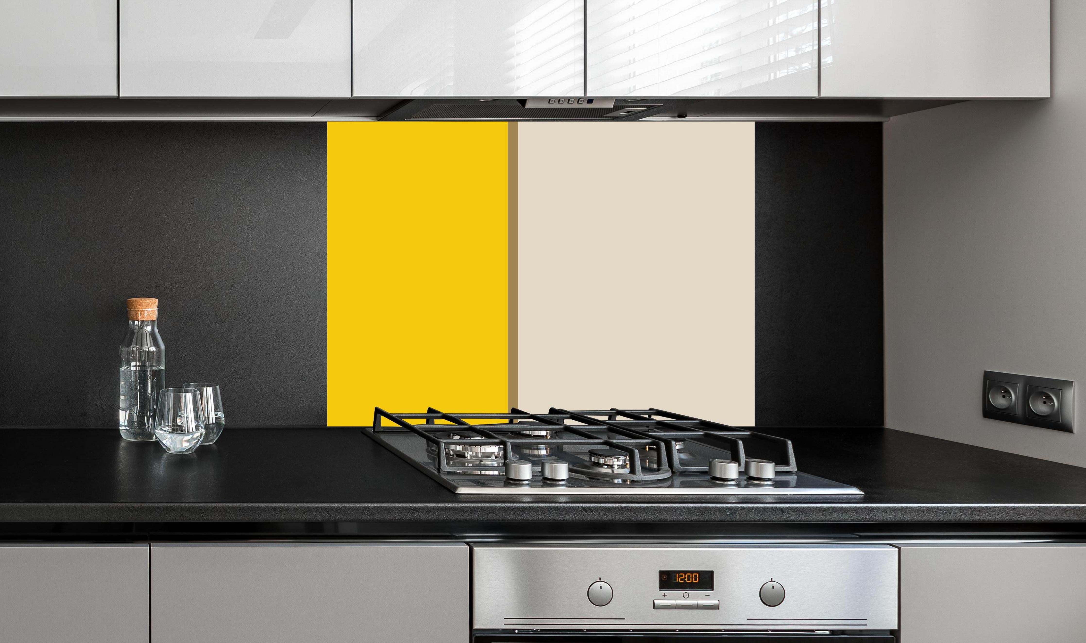 Spritzschutz - The Yellows - Easy Vertical - Saffron hinter einem Cerankochfeld zwischen Holz-Kochutensilien