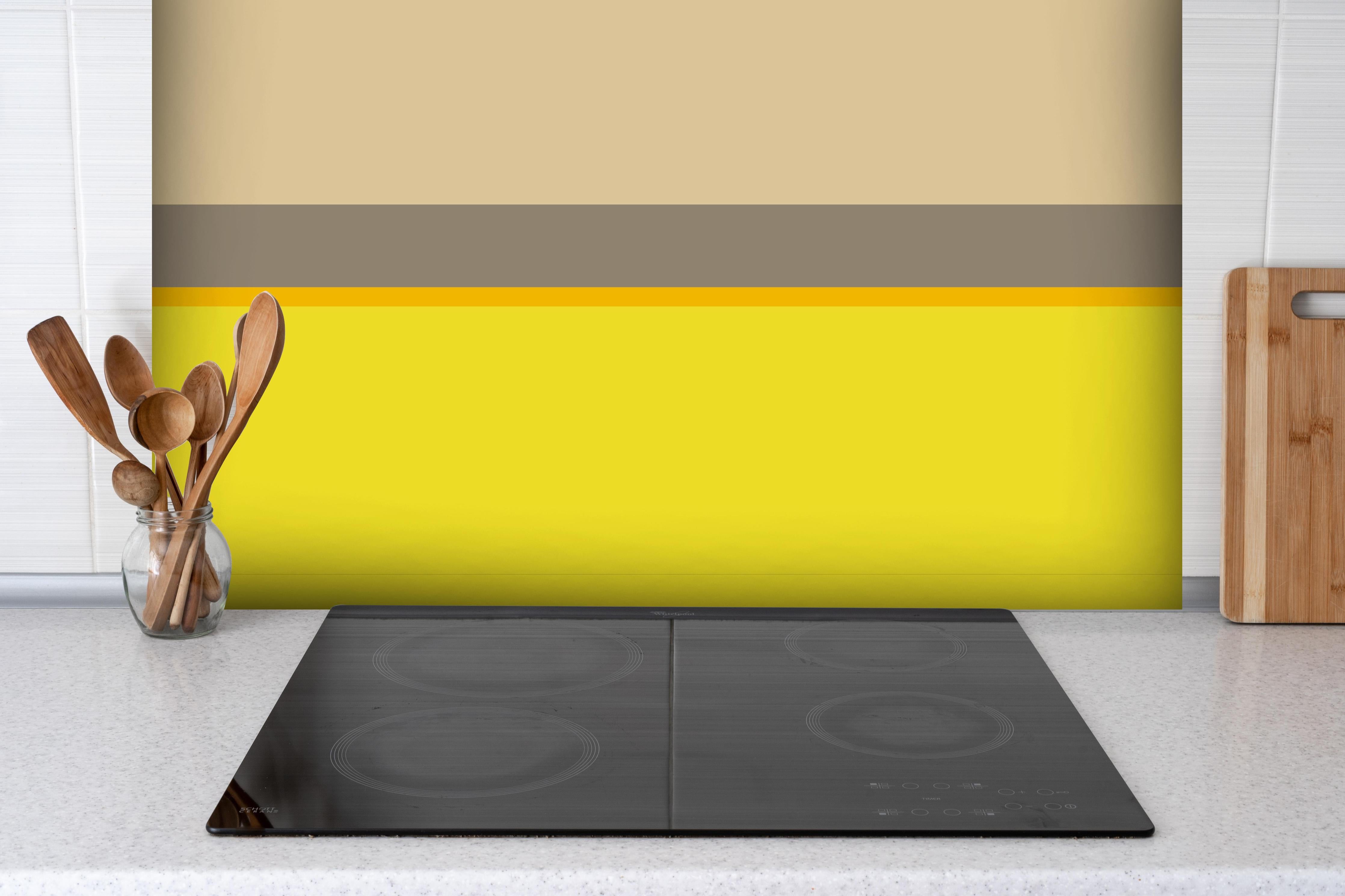 Spritzschutz - The Yellows - Horizontal - Honey hinter einem Cerankochfeld zwischen Holz-Kochutensilien
