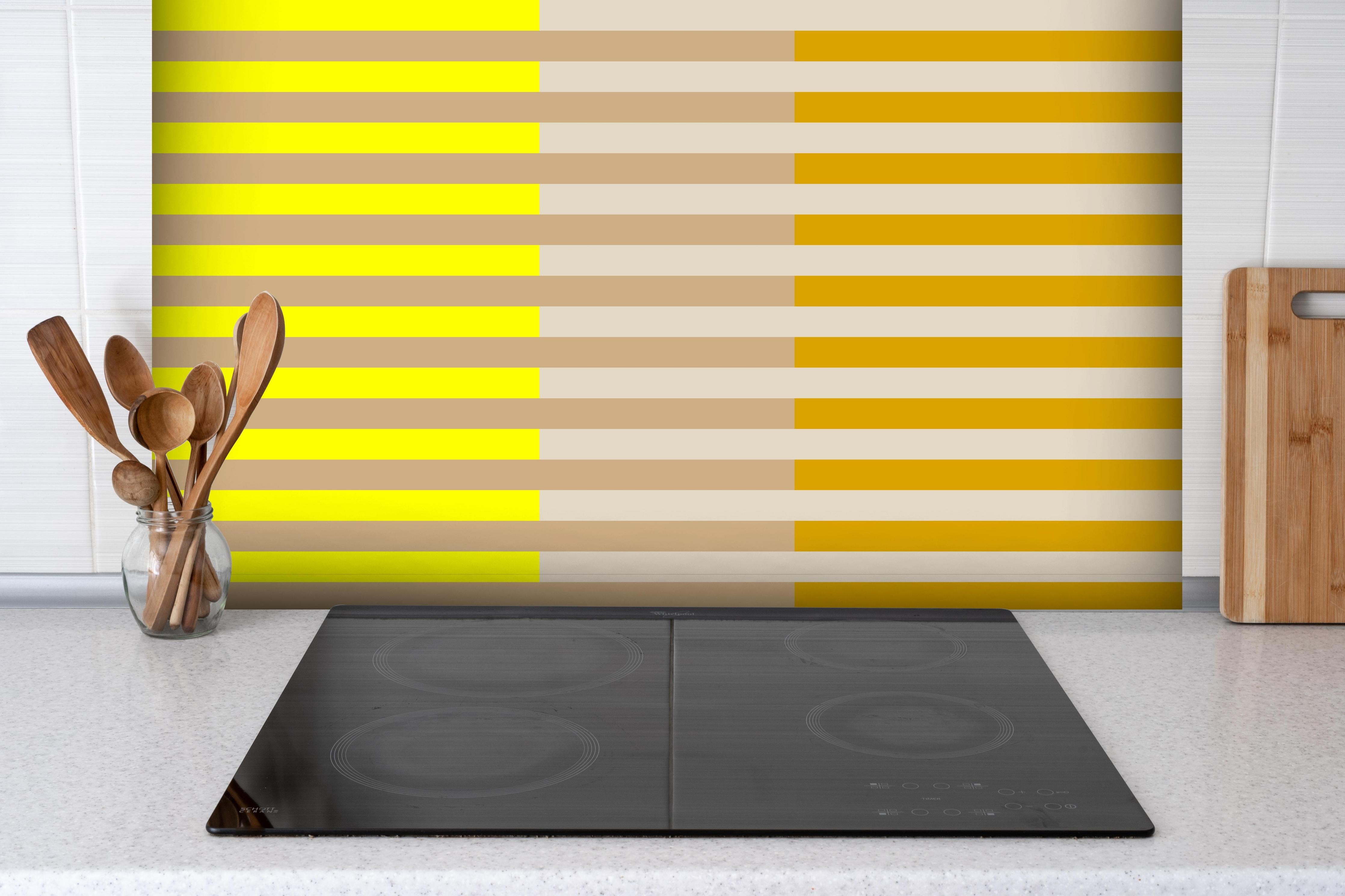 Spritzschutz - The Yellows - Multy Stripes - Buttercup hinter einem Cerankochfeld zwischen Holz-Kochutensilien