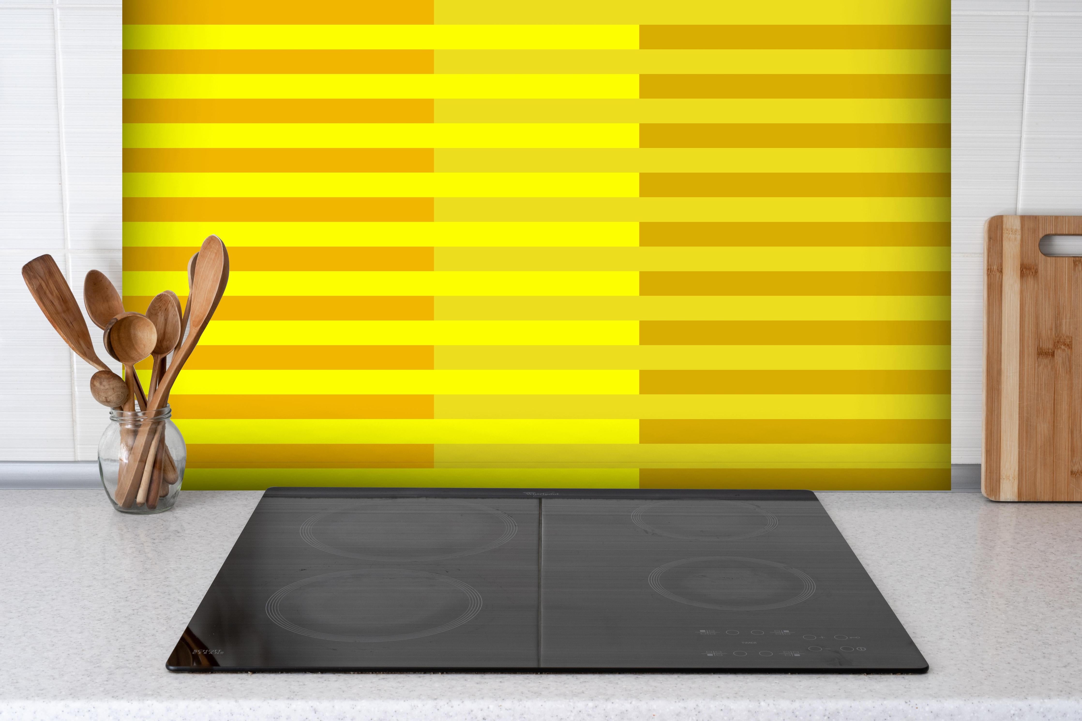 Spritzschutz - The Yellows - Multy Stripes - Lemon hinter einem Cerankochfeld zwischen Holz-Kochutensilien