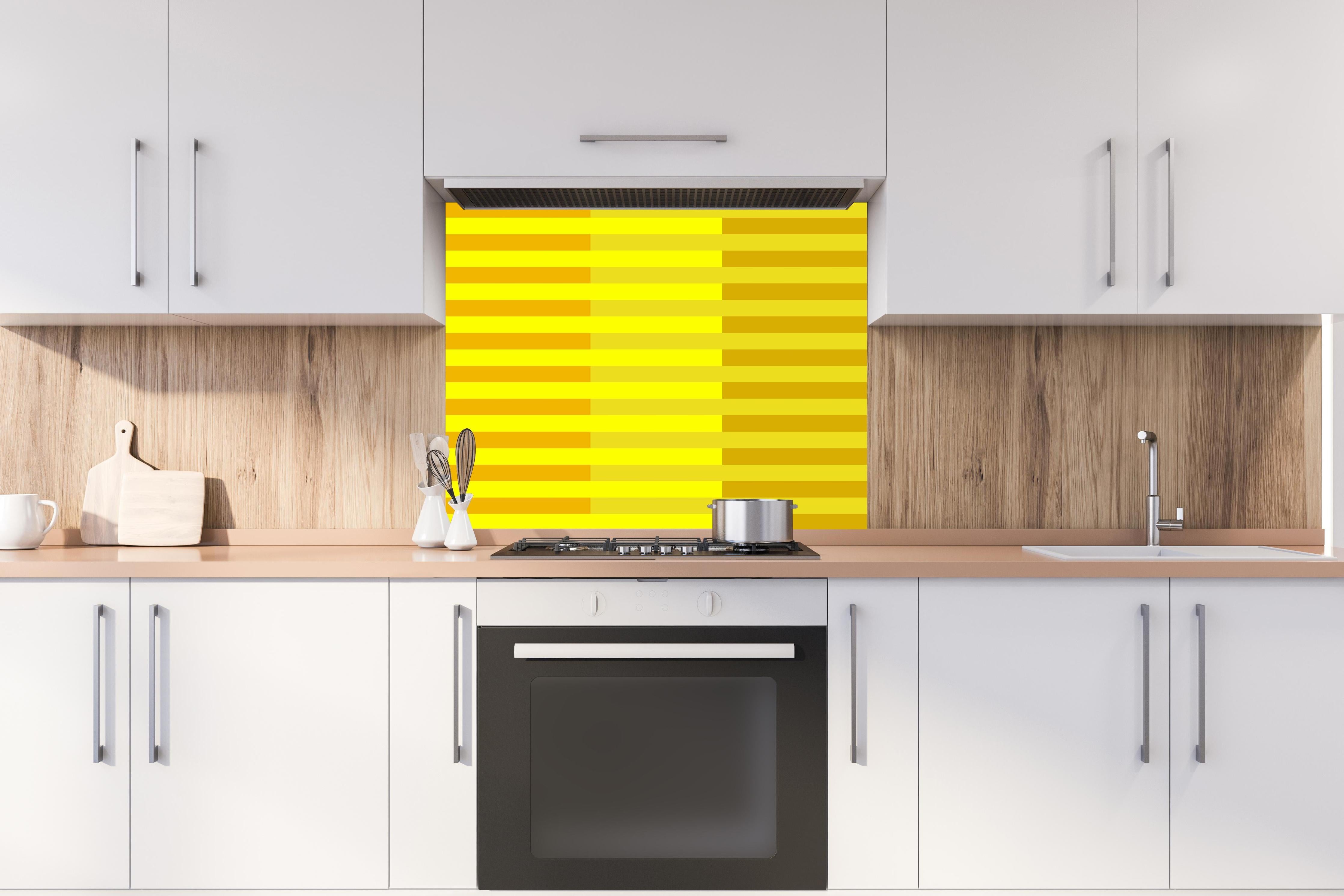 Spritzschutz - The Yellows - Multy Stripes - Lemon hinter einem Cerankochfeld zwischen Holz-Kochutensilien