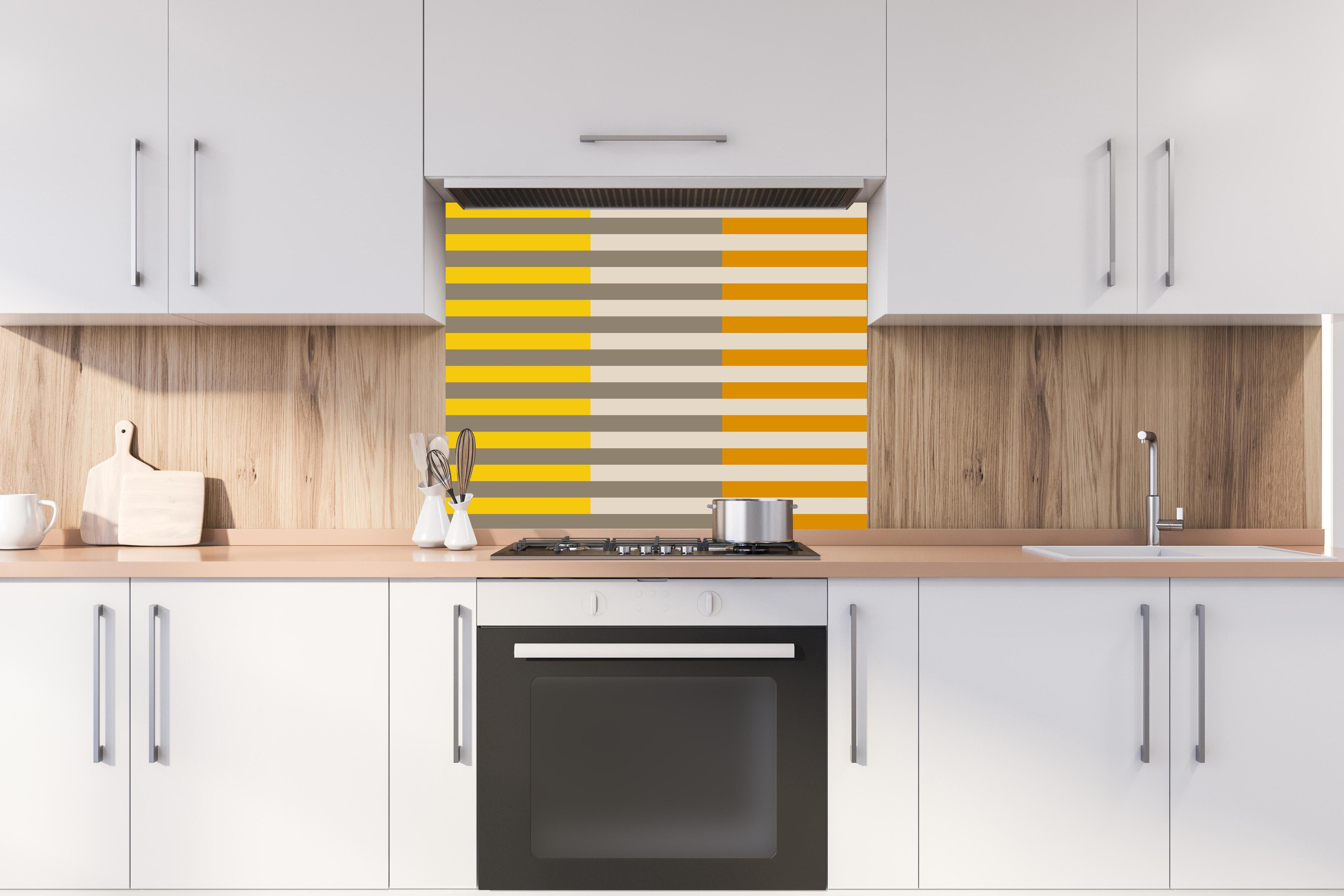 Spritzschutz - The Yellows - Multy Stripes - Saffron hinter einem Cerankochfeld zwischen Holz-Kochutensilien