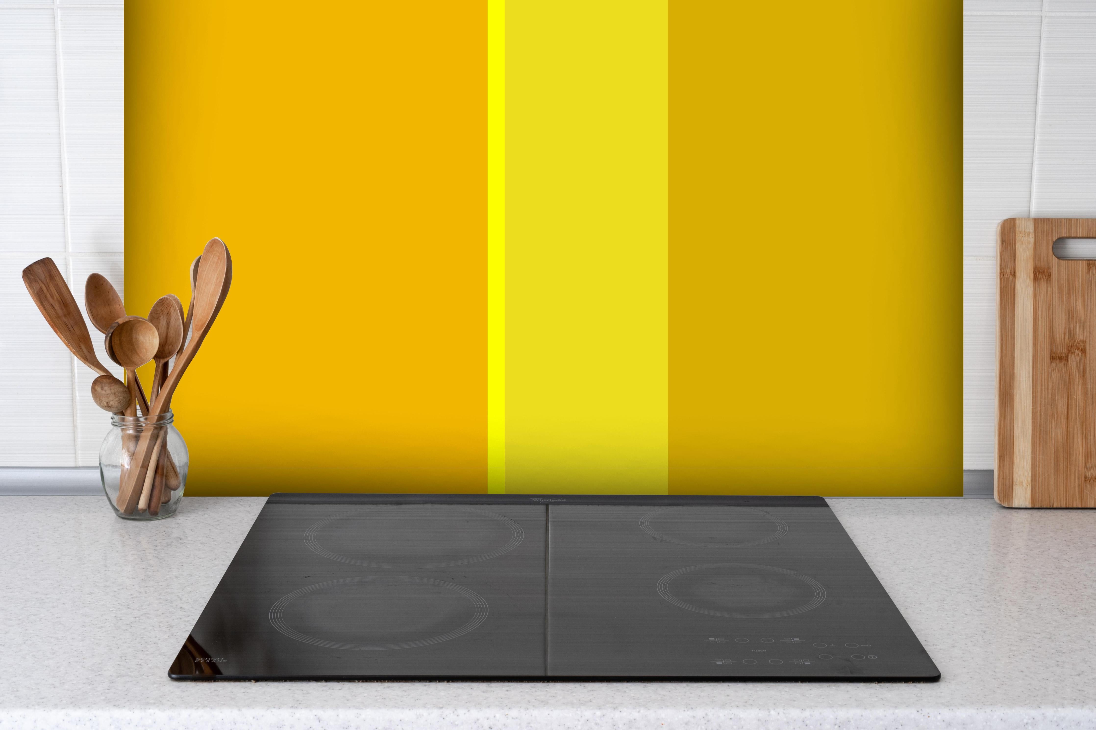 Spritzschutz - The Yellows - Vertical - Lemon hinter einem Cerankochfeld zwischen Holz-Kochutensilien
