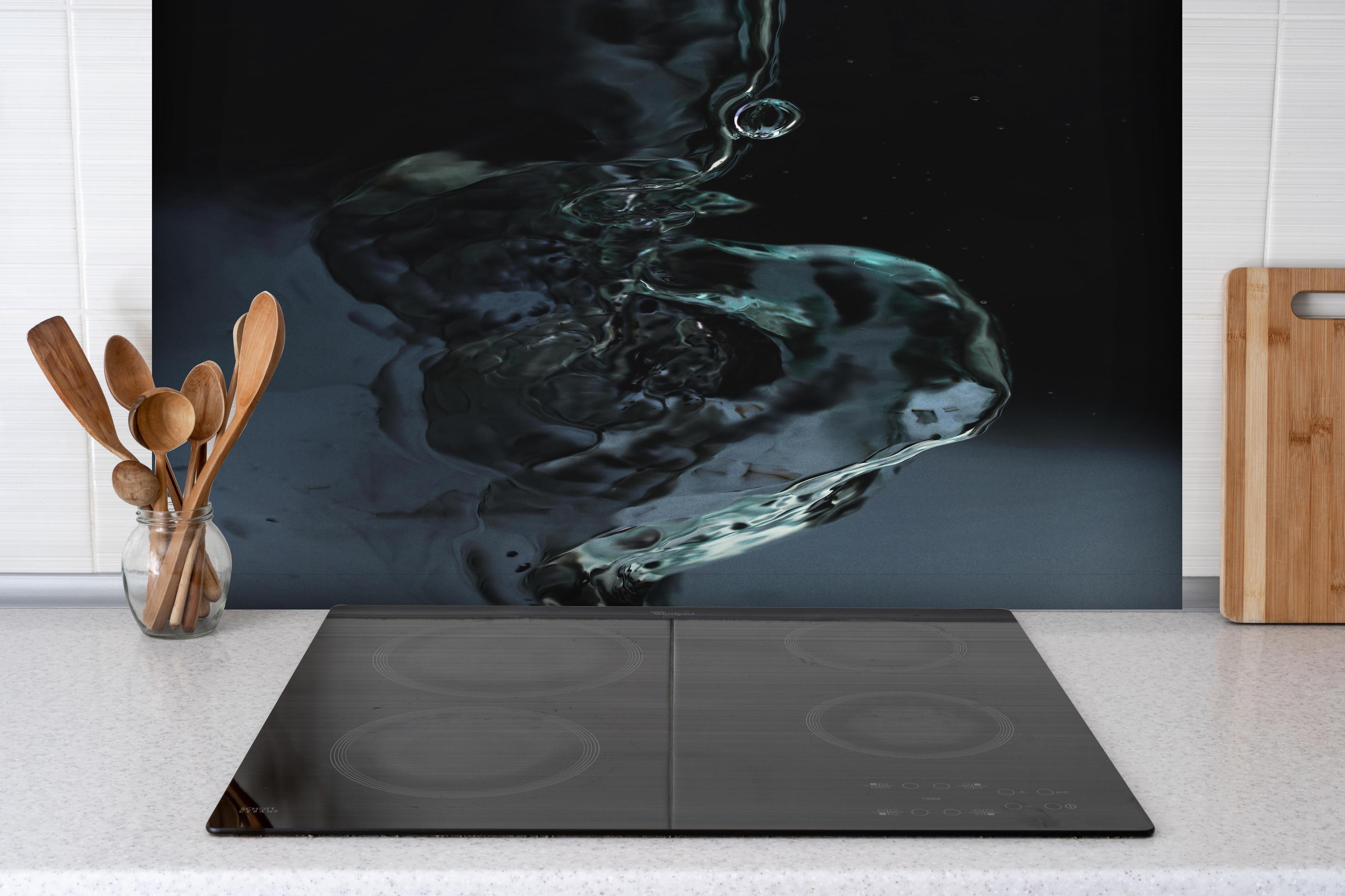 Spritzschutz - Tiefblaue Wasser-Tropfen-Kunst hinter einem Cerankochfeld zwischen Holz-Kochutensilien