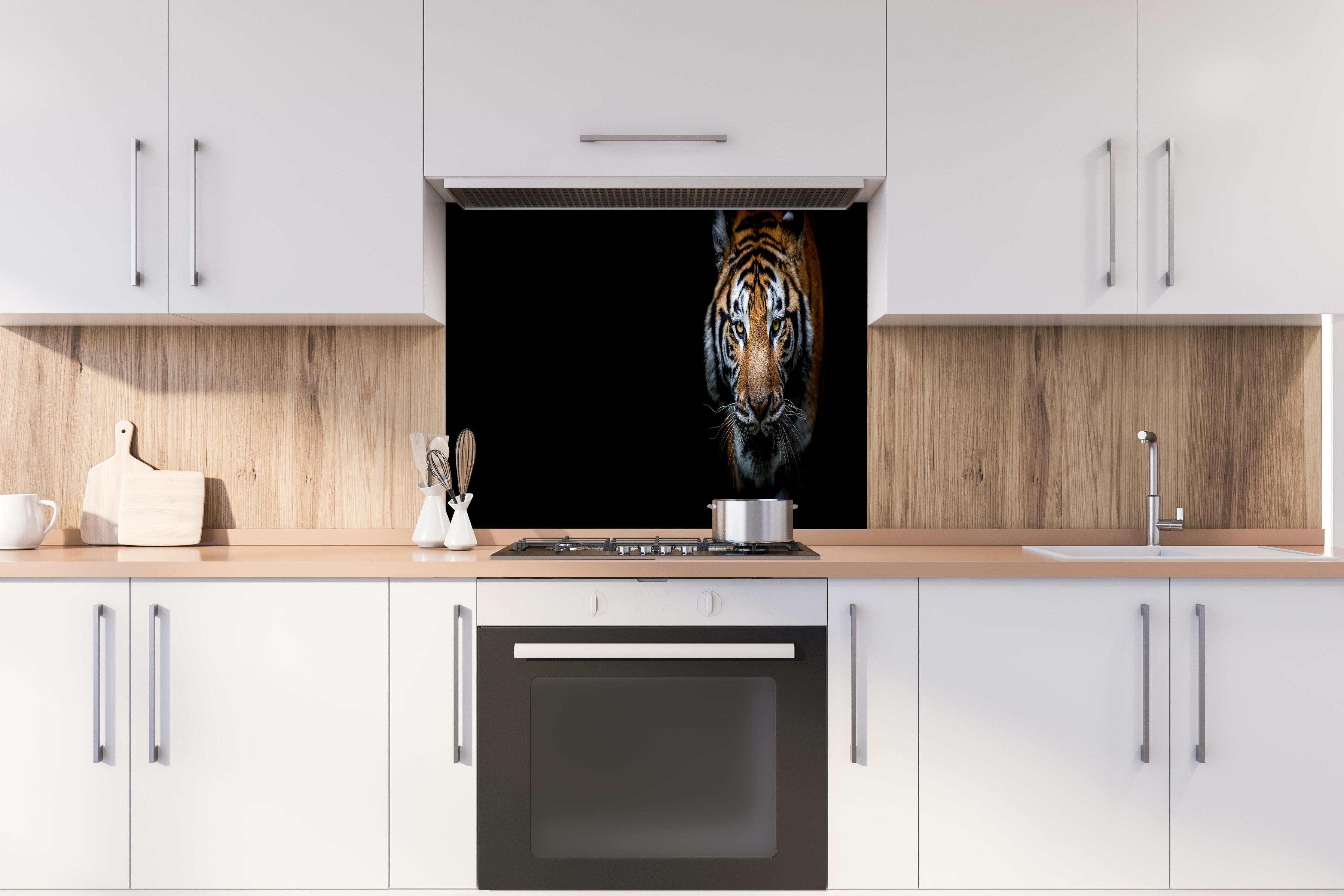 Spritzschutz - Tiger auf schwarzem Hintergrund hinter einem Cerankochfeld zwischen Holz-Kochutensilien