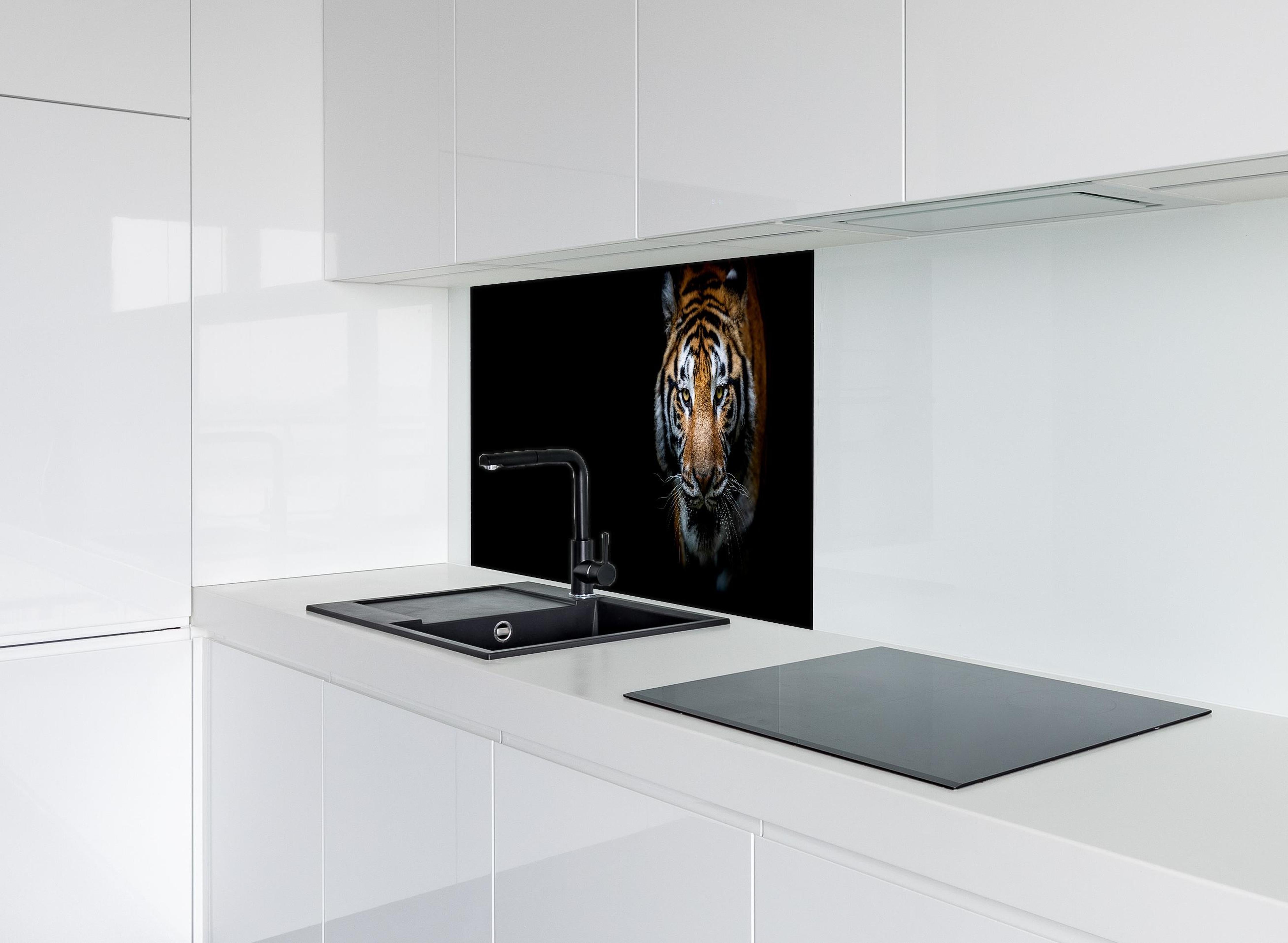 Spritzschutz - Tiger auf schwarzem Hintergrund hinter einem Cerankochfeld zwischen Holz-Kochutensilien