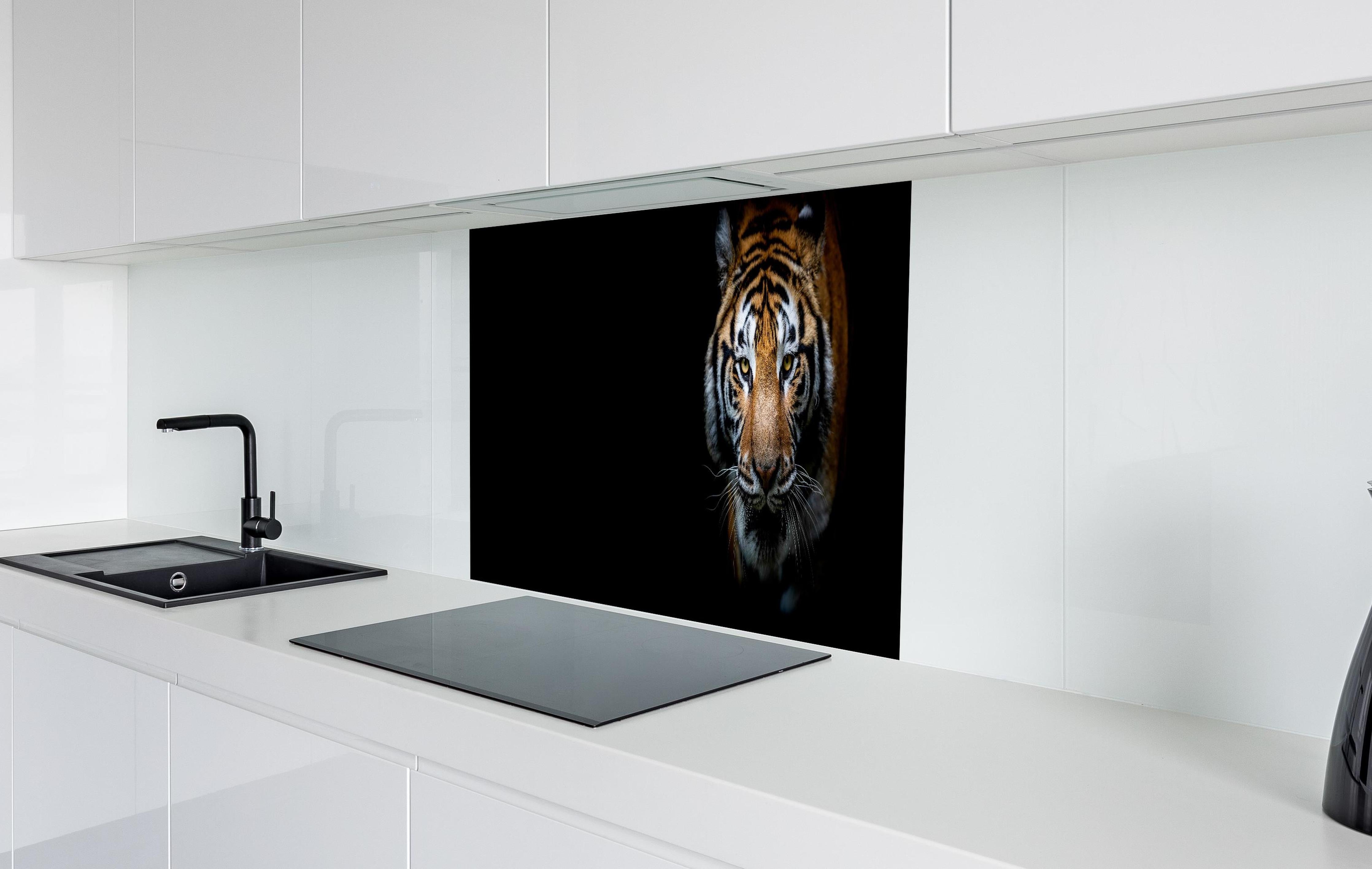 Spritzschutz - Tiger auf schwarzem Hintergrund hinter einem Cerankochfeld zwischen Holz-Kochutensilien