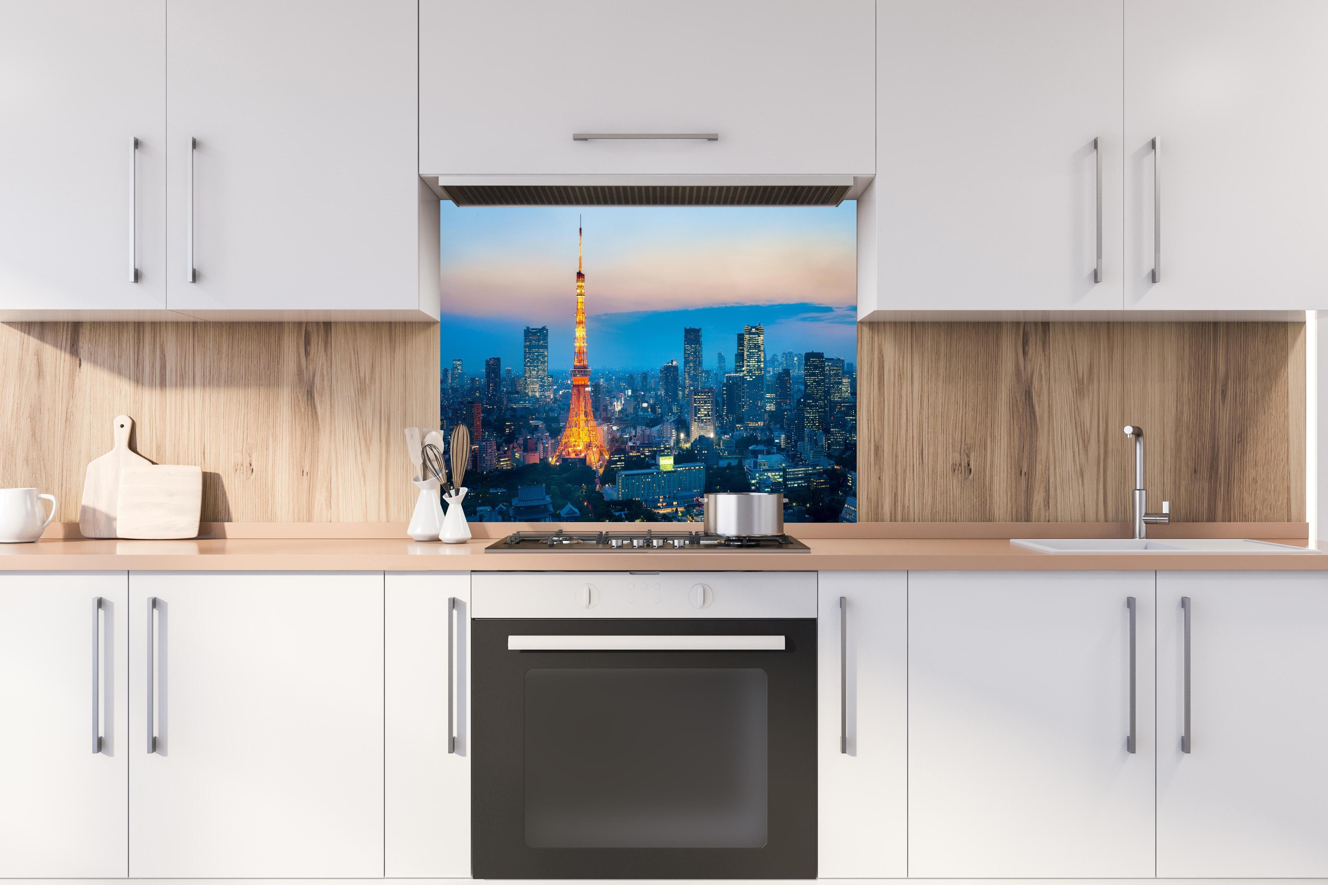 Spritzschutz - Tokyo Tower bei Nacht hinter einem Cerankochfeld zwischen Holz-Kochutensilien