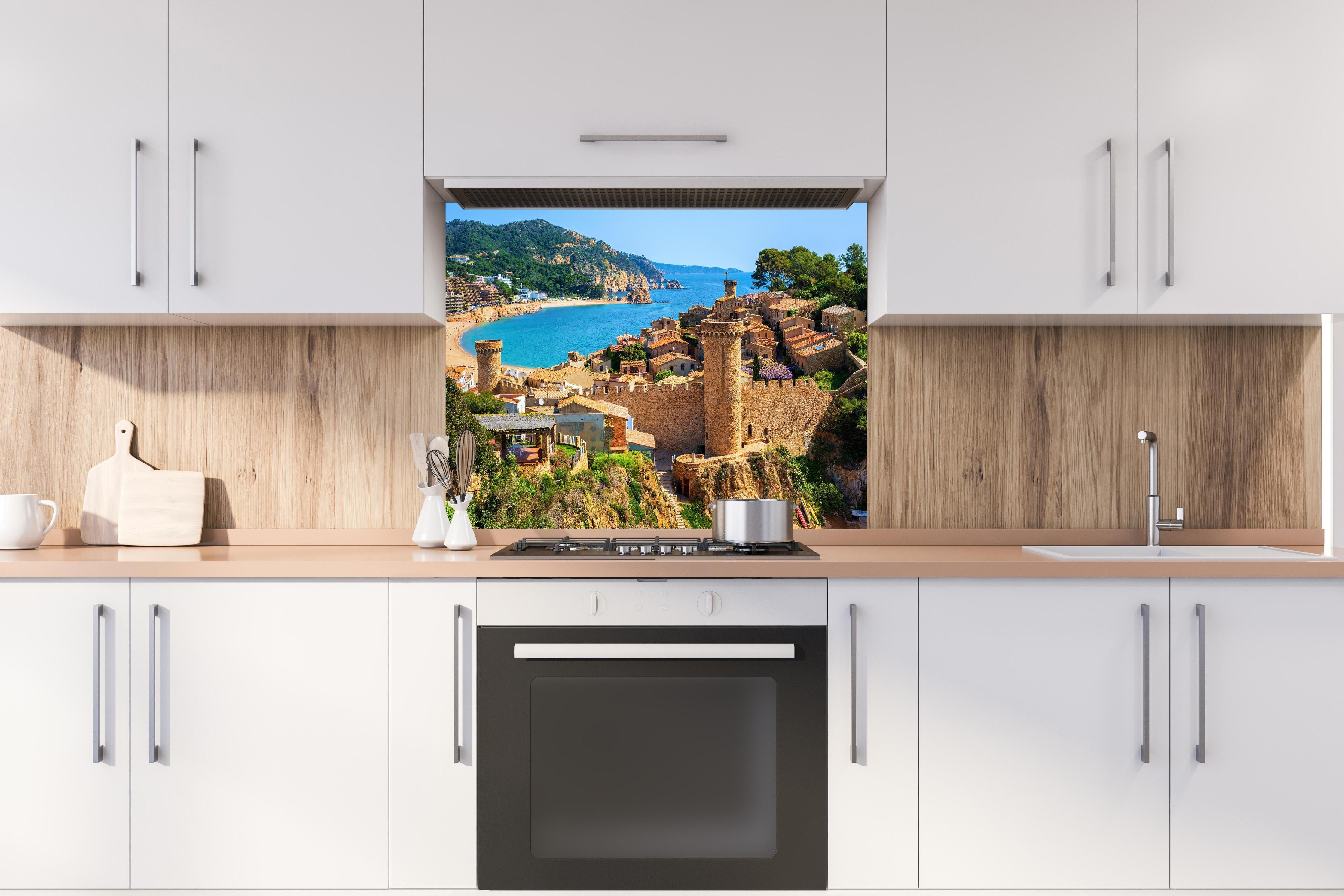 Spritzschutz - Tossa de Mar - Spanien hinter einem Cerankochfeld zwischen Holz-Kochutensilien
