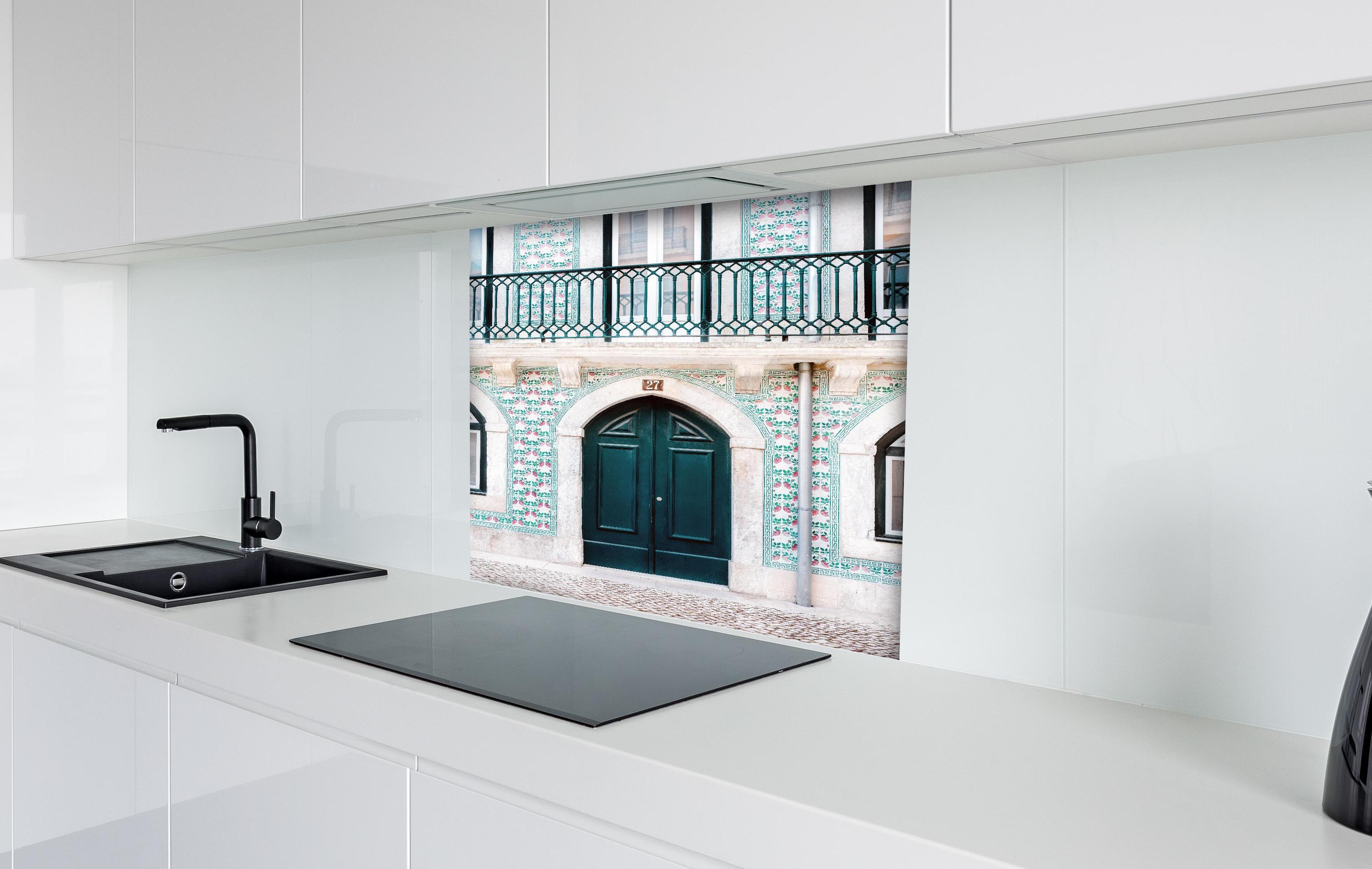 Spritzschutz - Traditionelle Tür Lissabons in Grün hinter einem Cerankochfeld zwischen Holz-Kochutensilien