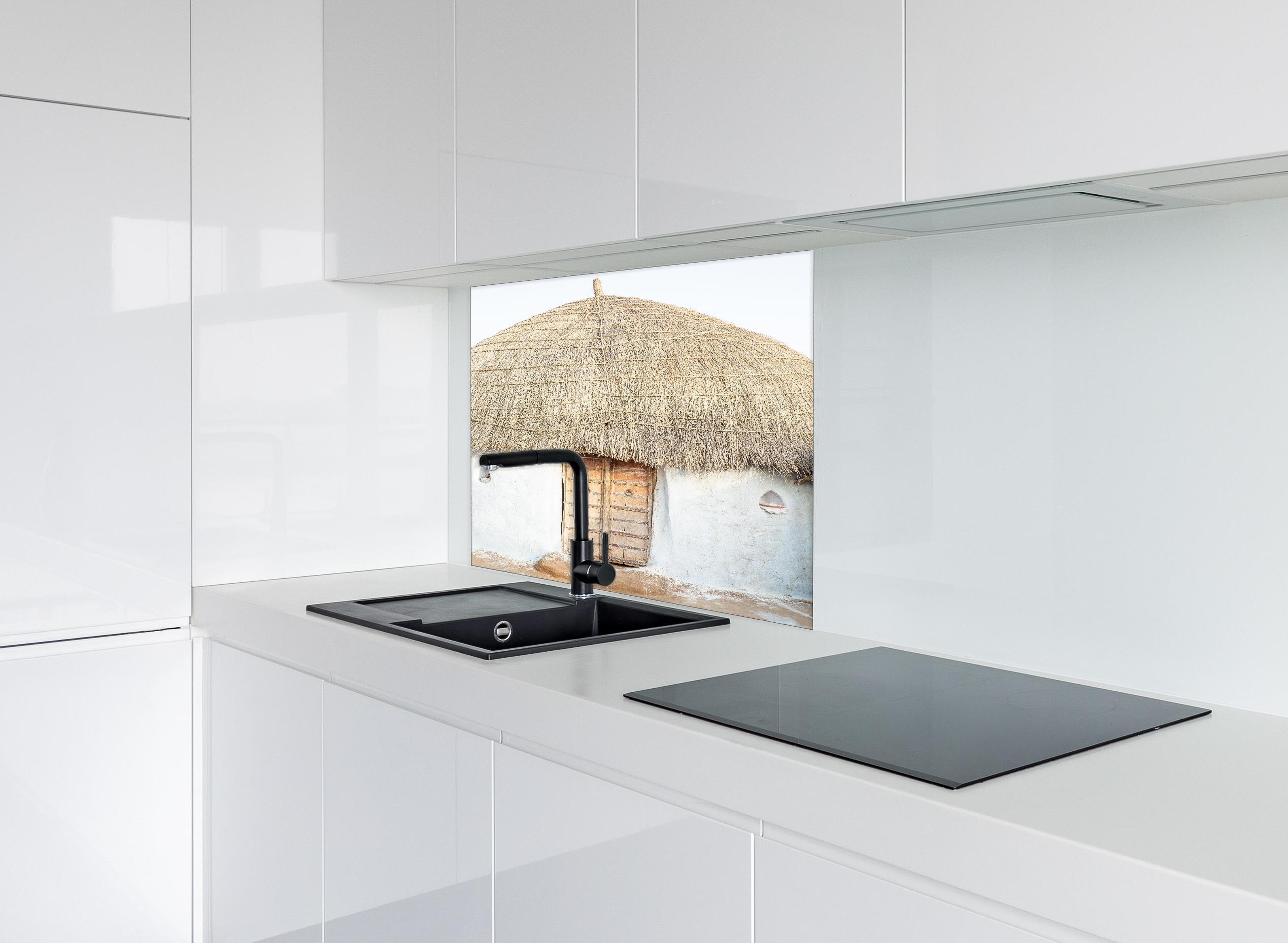 Spritzschutz - Traditionelle Wüstenhütte mit Strohdach hinter einem Cerankochfeld zwischen Holz-Kochutensilien