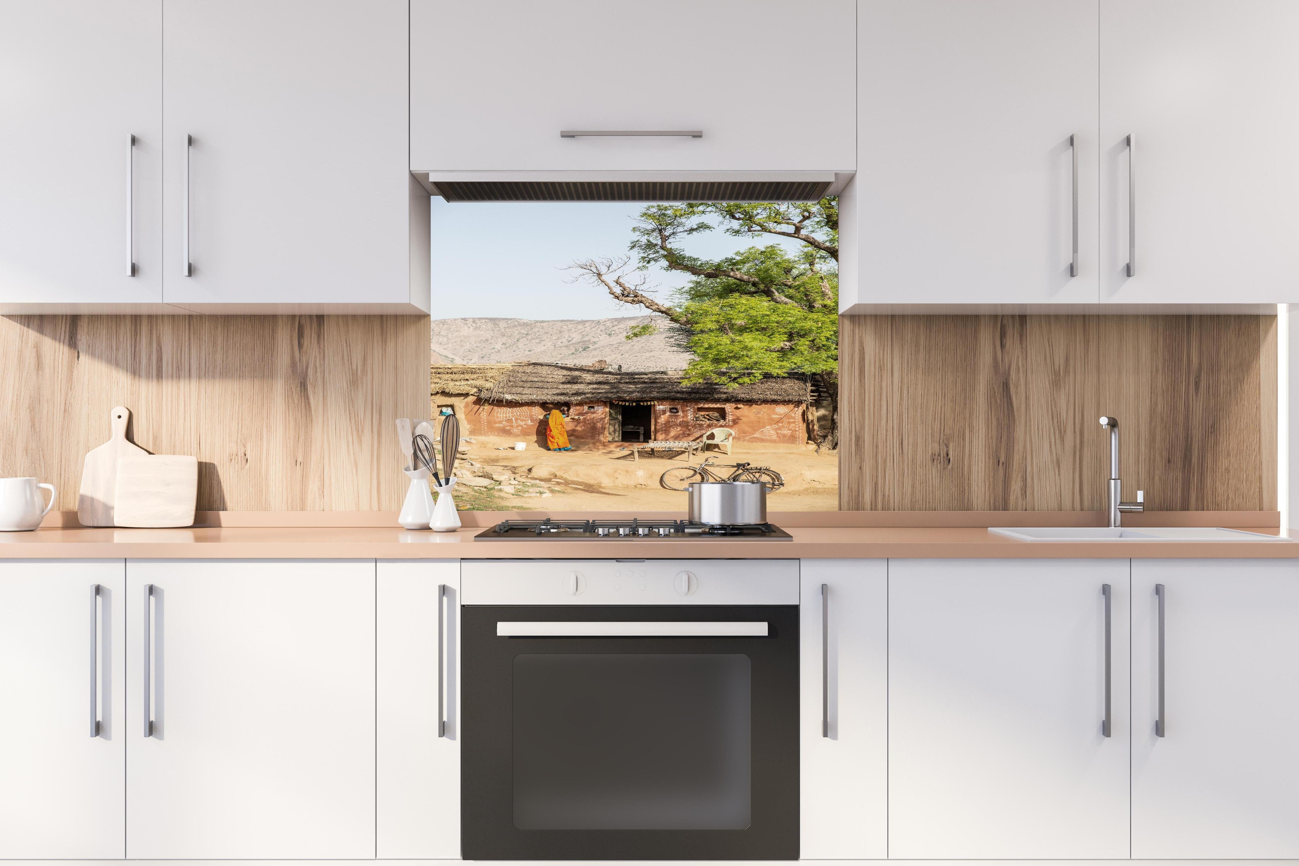 Spritzschutz - Traditionelles Dorf, Baum und Fahrrad hinter einem Cerankochfeld zwischen Holz-Kochutensilien