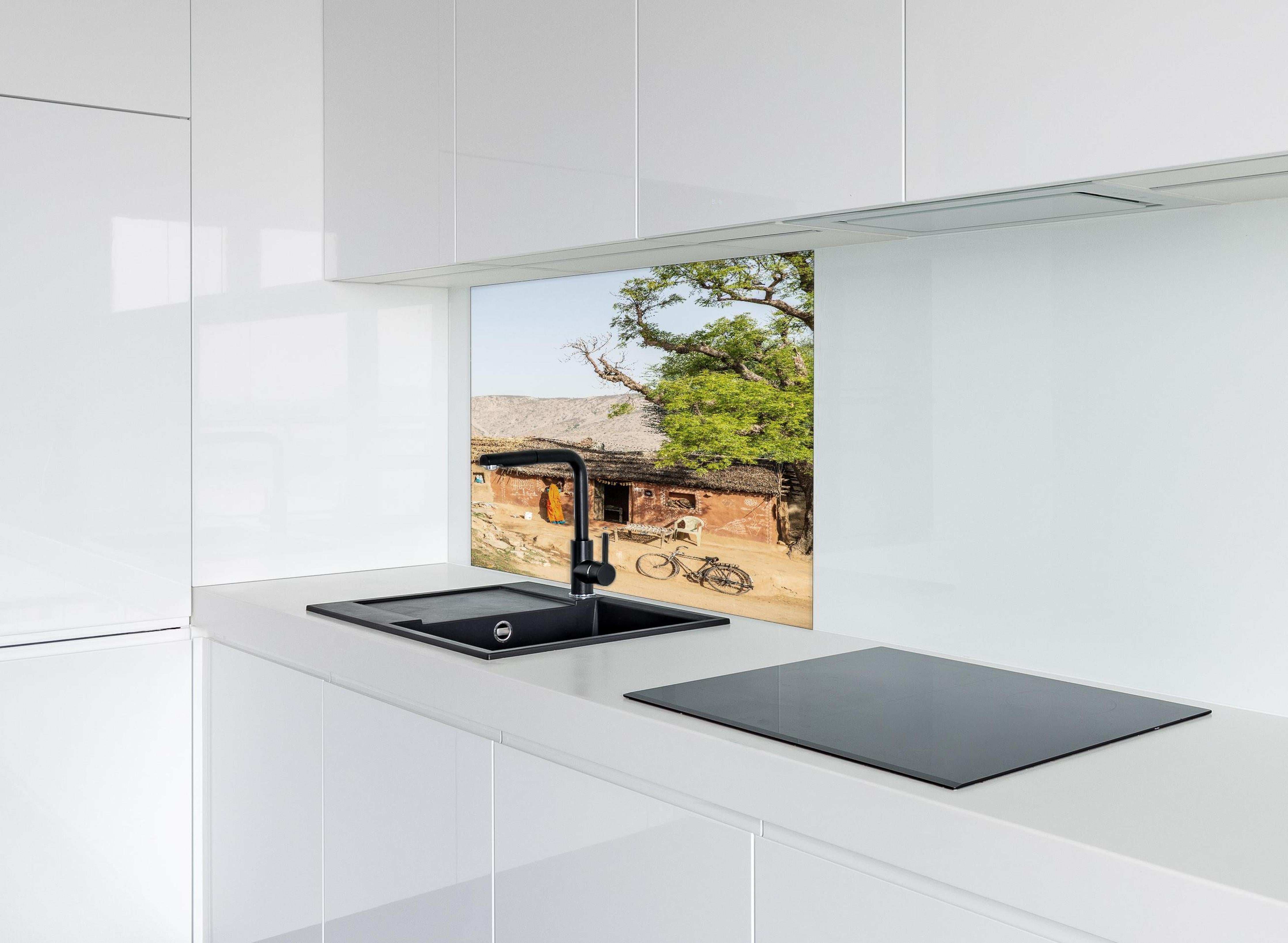 Spritzschutz - Traditionelles Dorf, Baum und Fahrrad hinter einem Cerankochfeld zwischen Holz-Kochutensilien