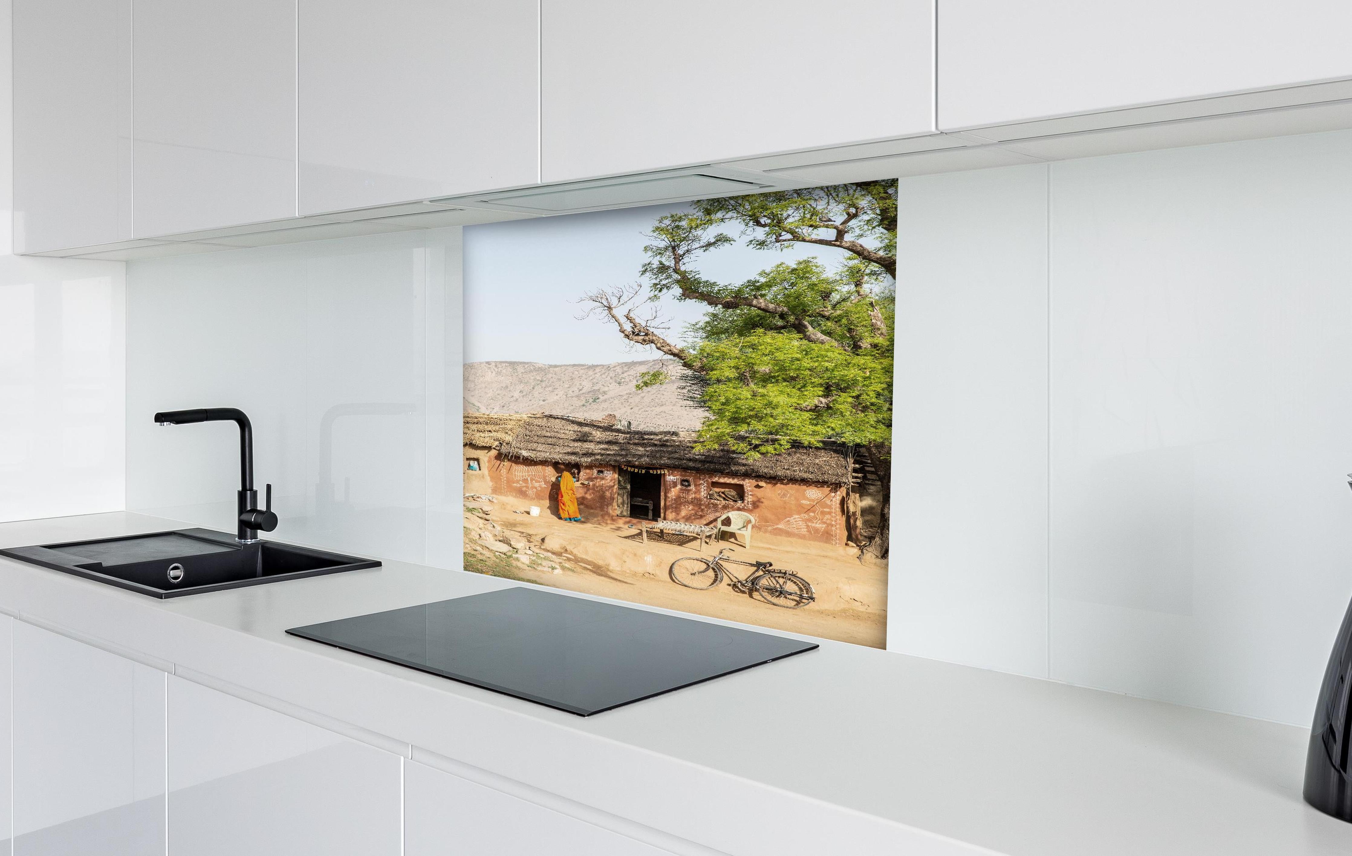 Spritzschutz - Traditionelles Dorf, Baum und Fahrrad hinter einem Cerankochfeld zwischen Holz-Kochutensilien