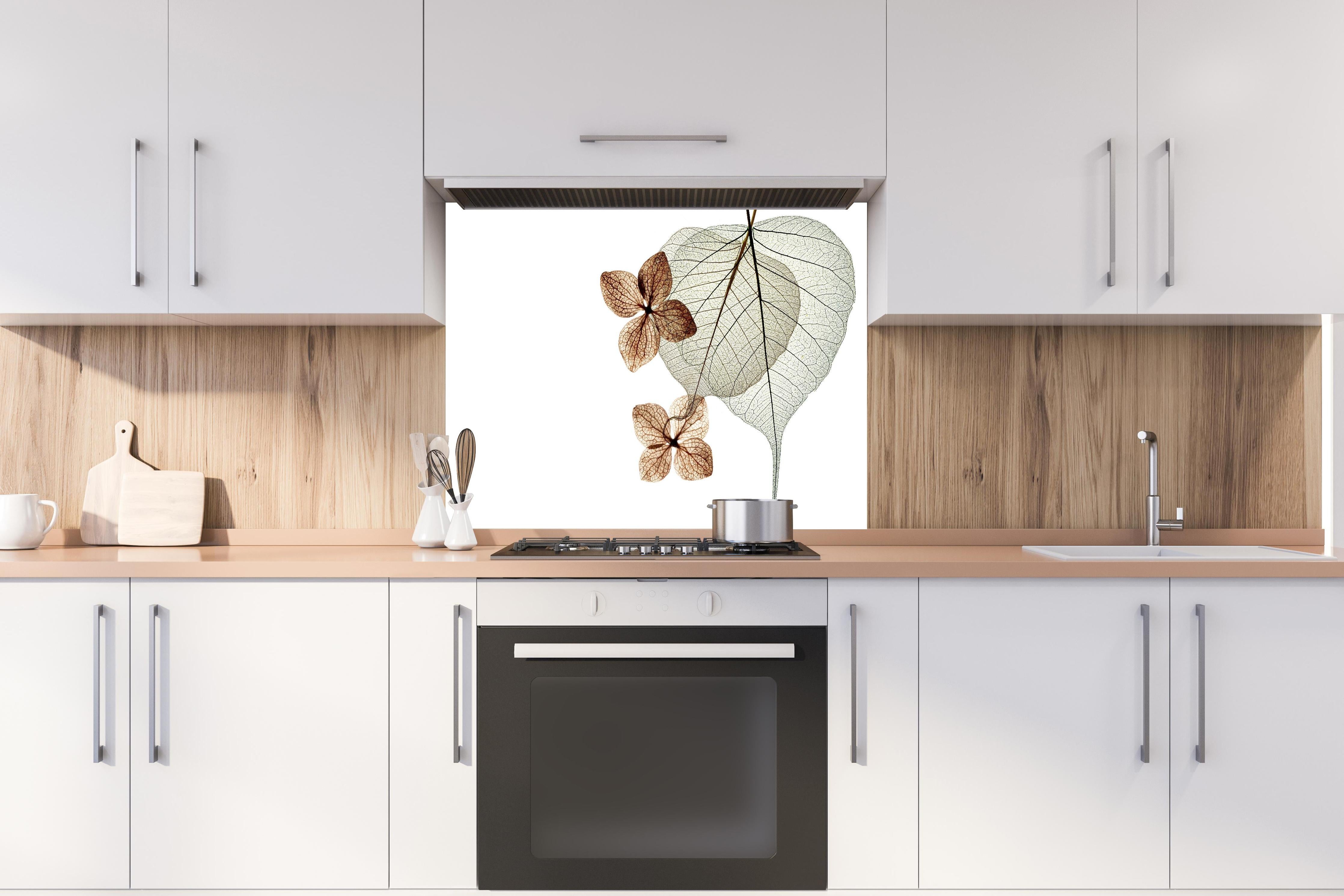 Spritzschutz - Transparente Blattstrukturen in Weiß-Grau hinter einem Cerankochfeld zwischen Holz-Kochutensilien