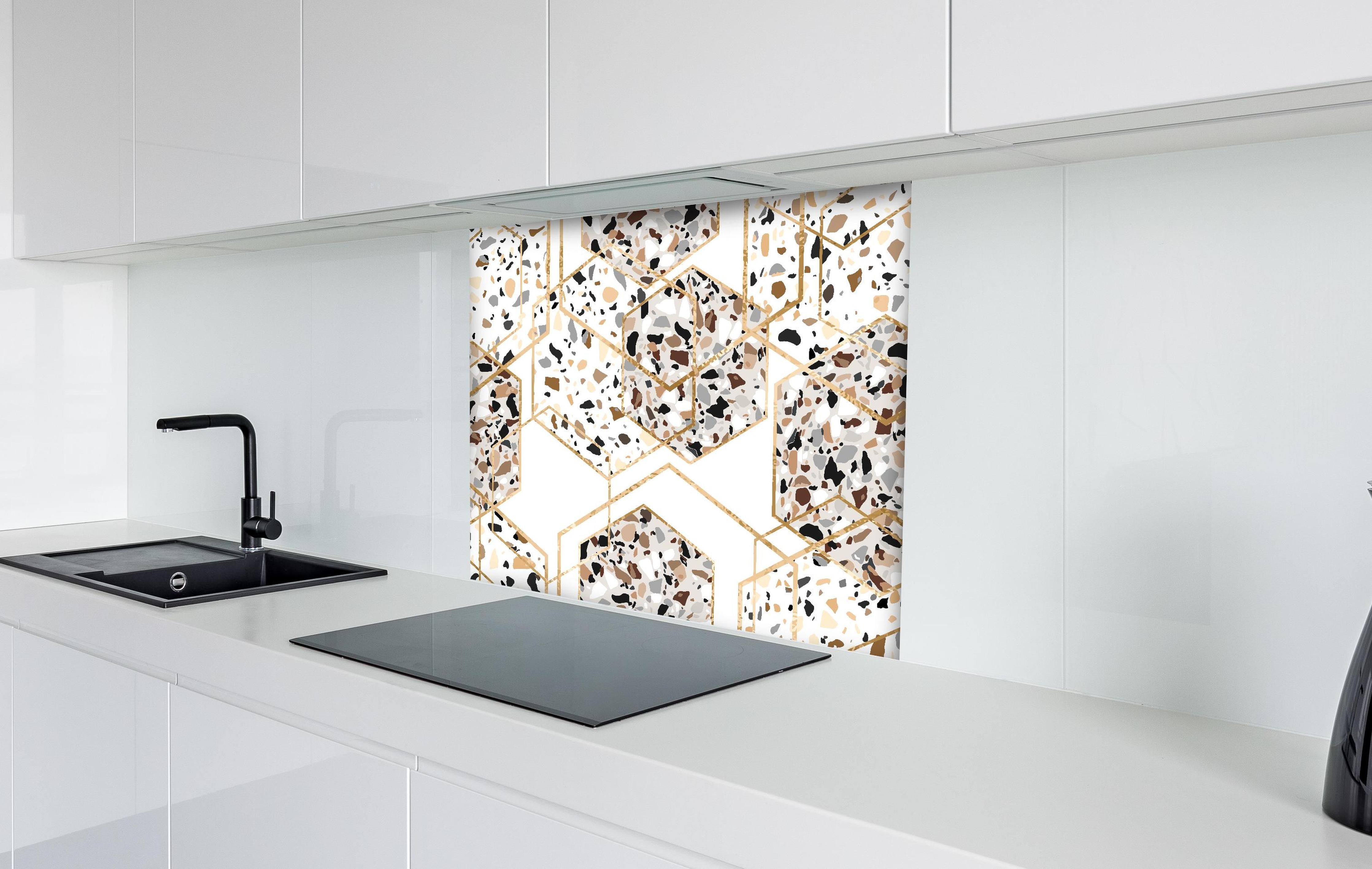 Spritzschutz - Trendiges Terrazzo-Muster mit Goldakzenten hinter einem Cerankochfeld zwischen Holz-Kochutensilien